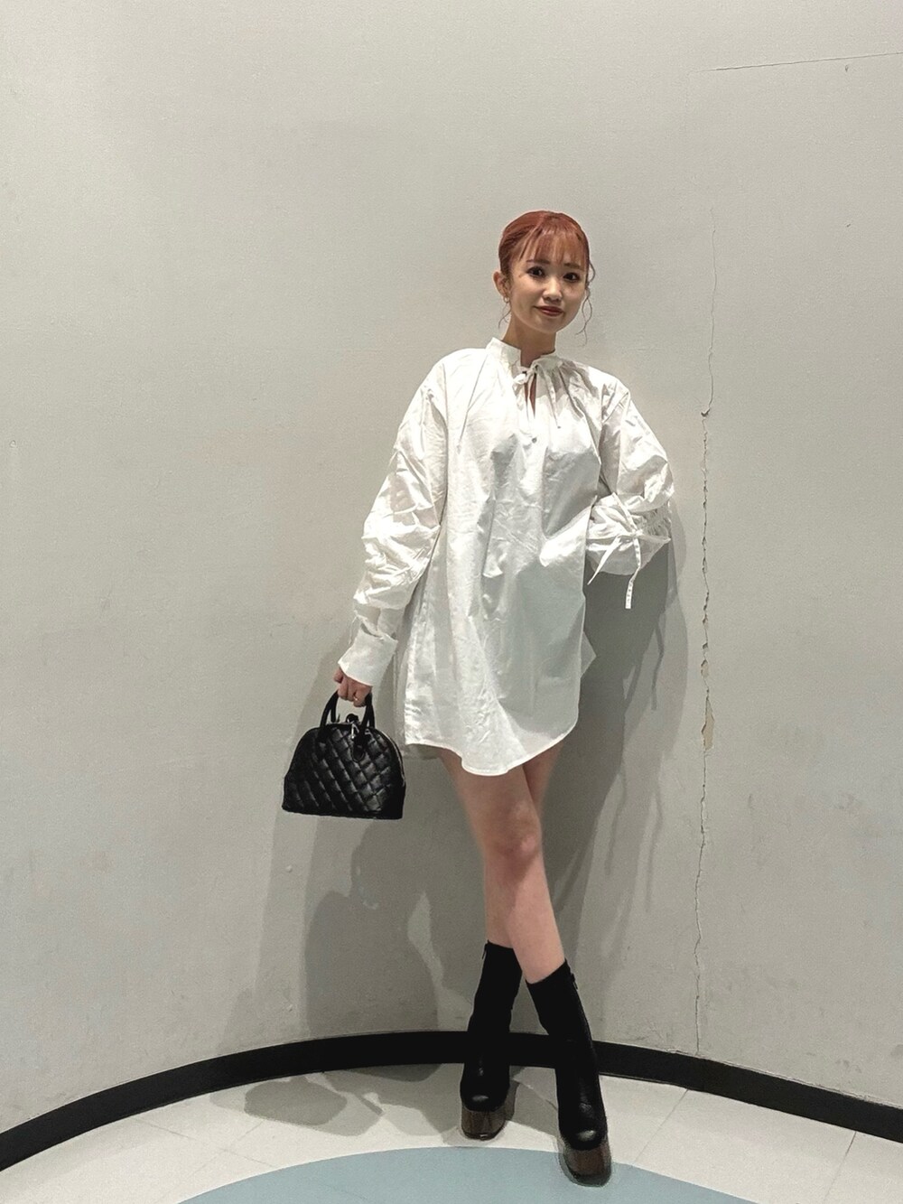 ブラウン系のブルゾン、グレー系のその他パンツ、ブラック系のハンドバッグを着用したレディースの冬コーディネートの2枚目の写真