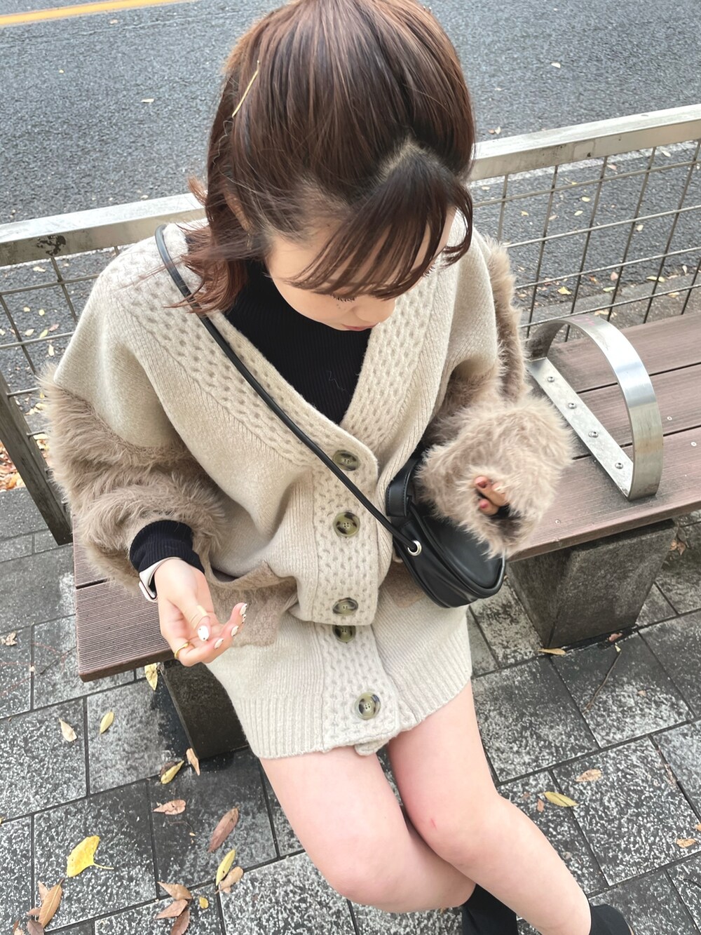 ベージュ系のカーディガン/ボレロ、ブラック系のブーツ、ブラック系のハンドバッグを着用したレディースの秋コーディネートの4枚目の写真