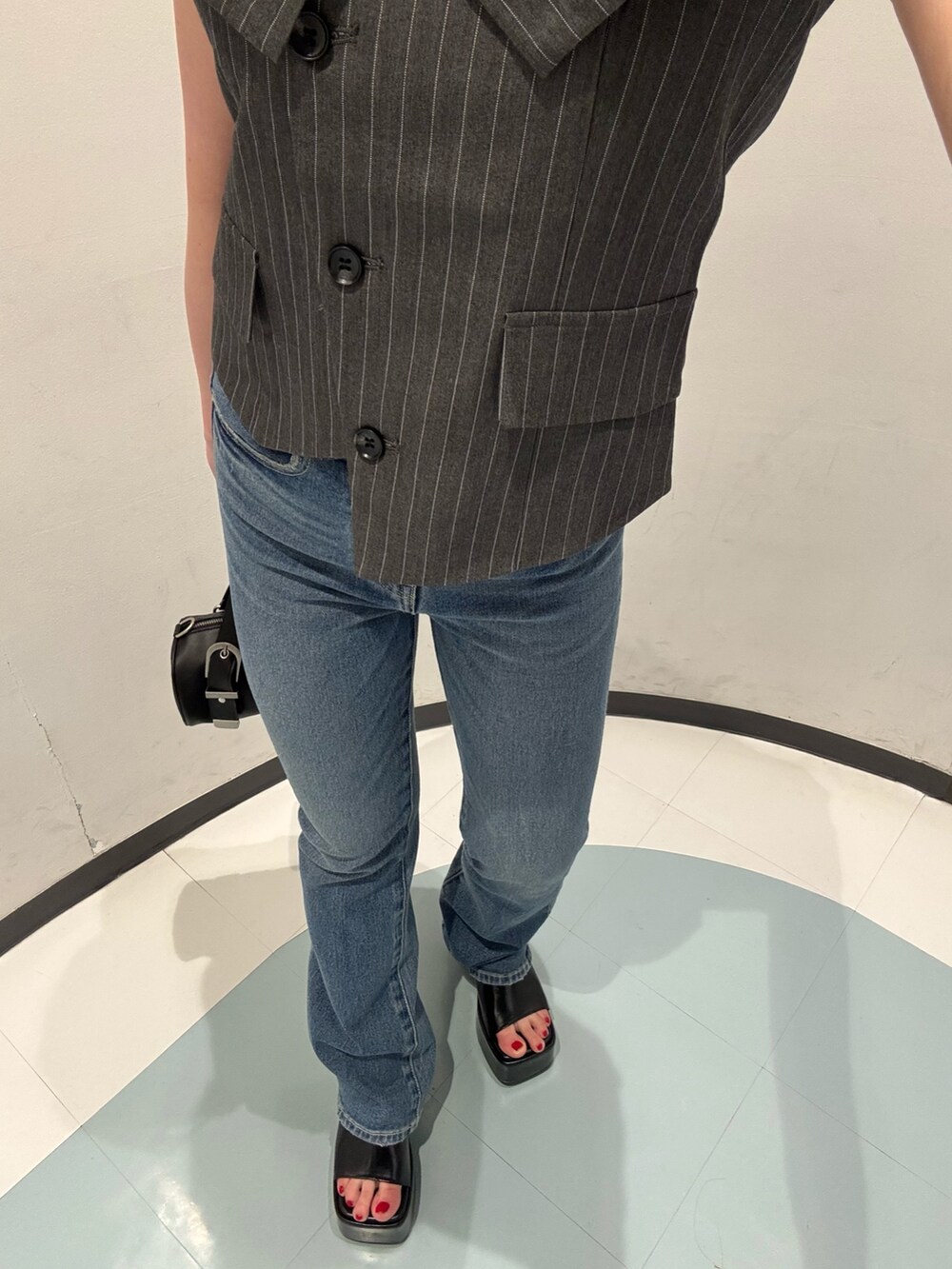 ブラック系のハンドバッグ、グレー系のシャツ/ブラウス、ブラック系のサンダルを着用したレディースの春コーディネートの5枚目の写真