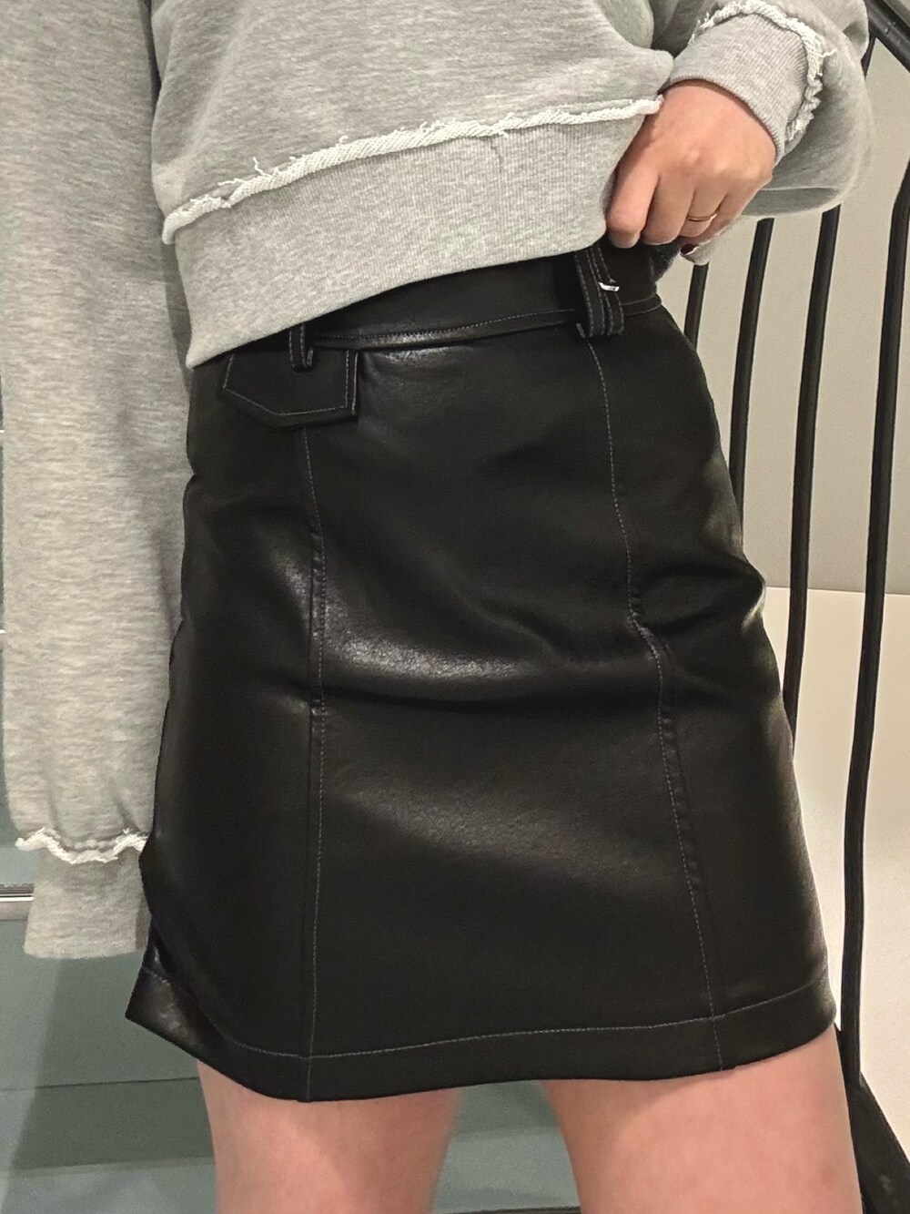 グレー系のスウェット、ブラック系のスカート、ブラック系のブーツを着用したレディースの冬コーディネートの5枚目の写真