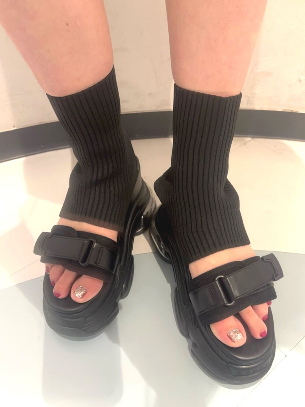 ブラック系のサンダル、ホワイト系のニット/セーター、ブルー系のベストを着用したレディースの夏コーディネートの7枚目の写真