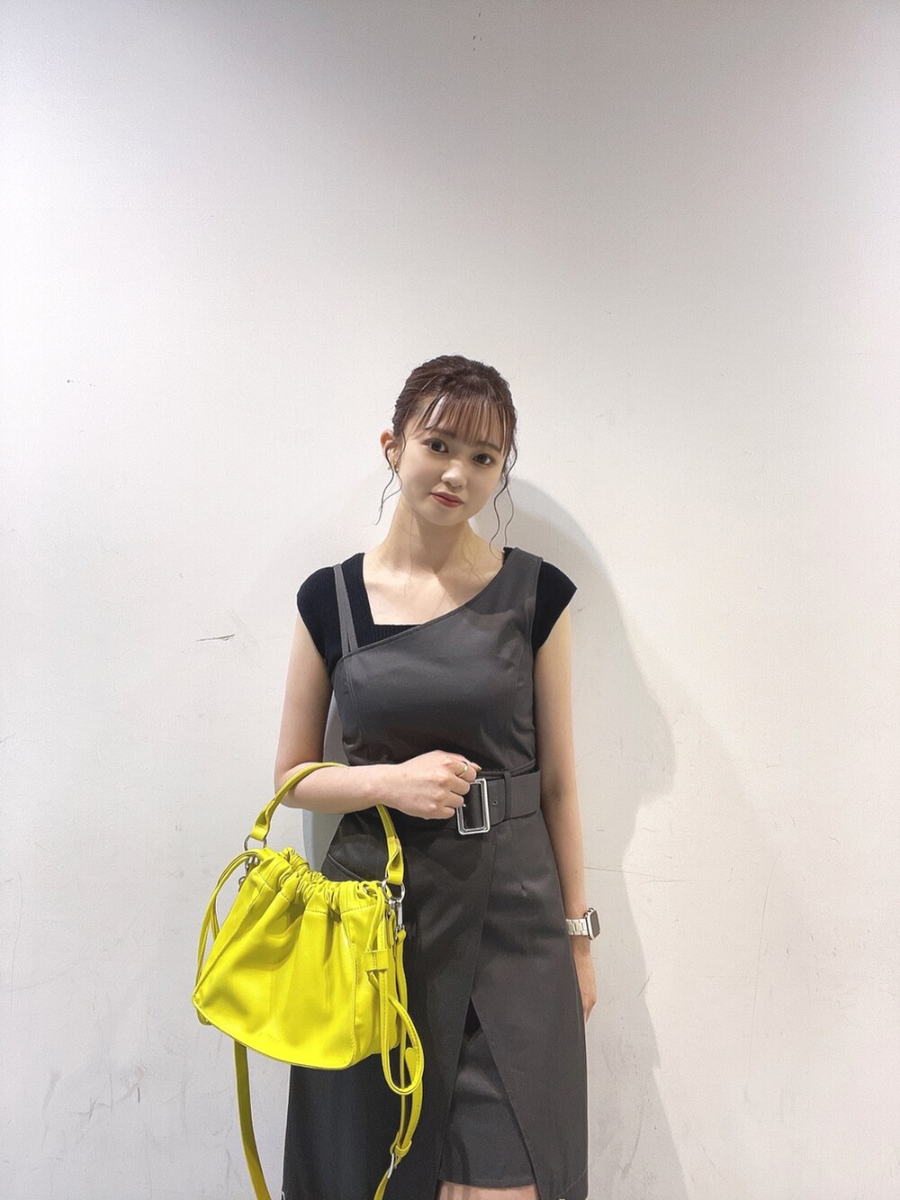 グレー系のワンピース、ブラック系のタンクトップ、イエロー系のハンドバッグを着用したレディースの夏コーディネートの2枚目の写真