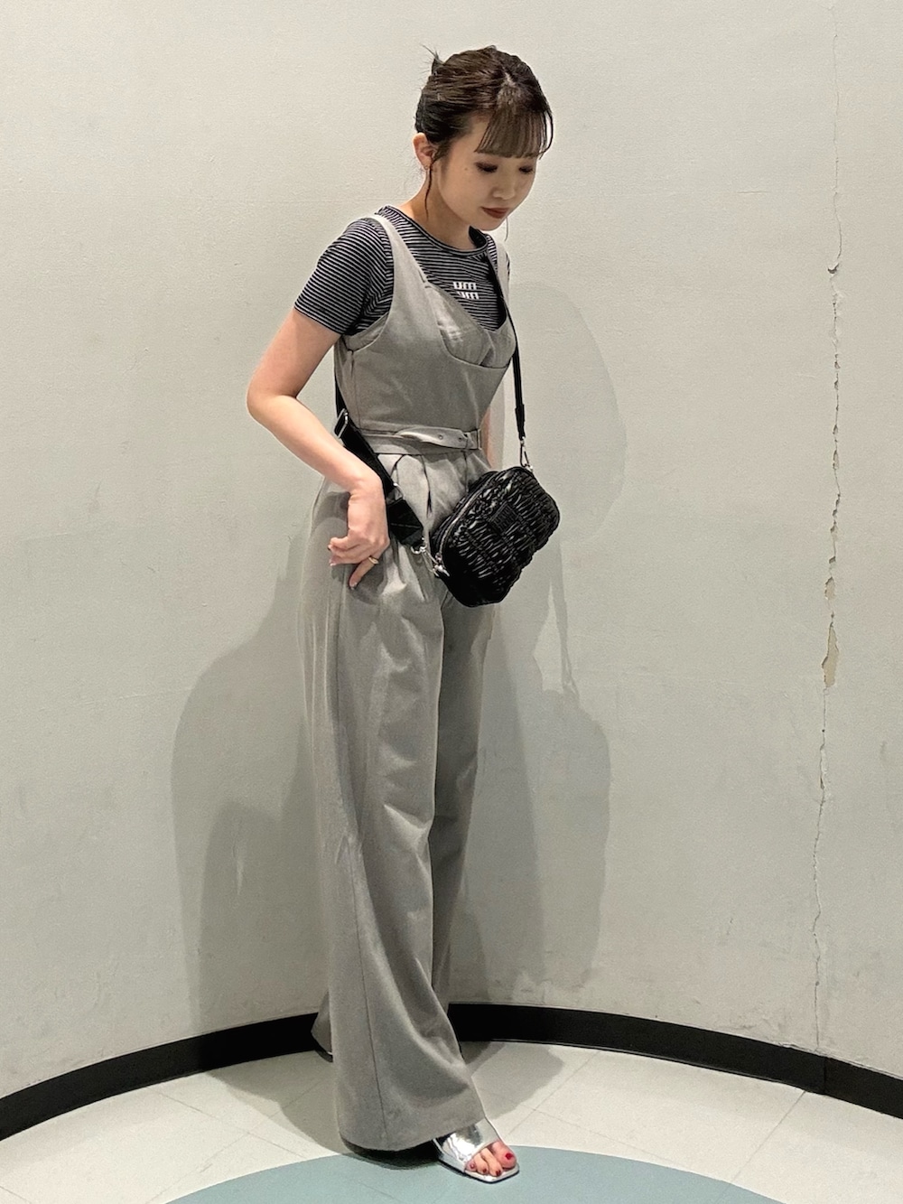 グレー系のワンピース、ブラック系のショルダーバッグ、シルバー系のサンダルを着用したレディースの春コーディネートの2枚目の写真