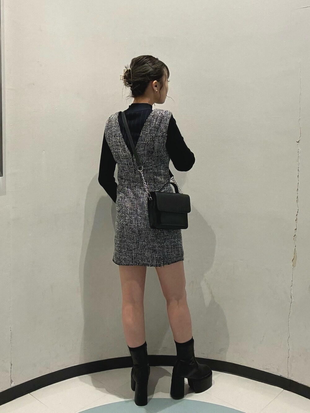 ブラック系のハンドバッグ、ブラック系のニット/セーター、ブラック系のワンピースを着用したレディースの冬コーディネートの4枚目の写真