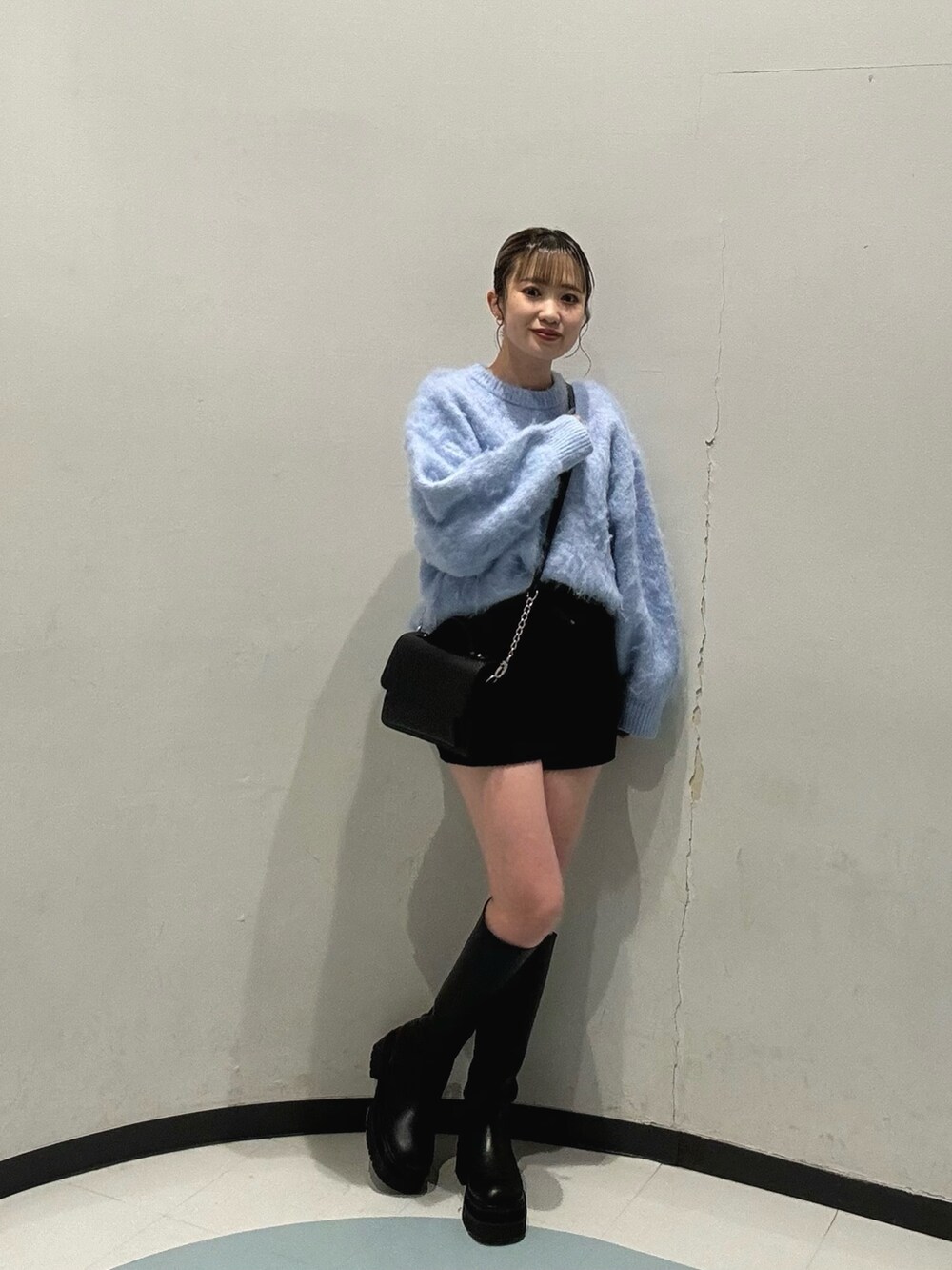 ブラック系のハンドバッグ、ブラック系のブルゾン、ブルー系のニット/セーターを着用したレディースの冬コーディネートの4枚目の写真