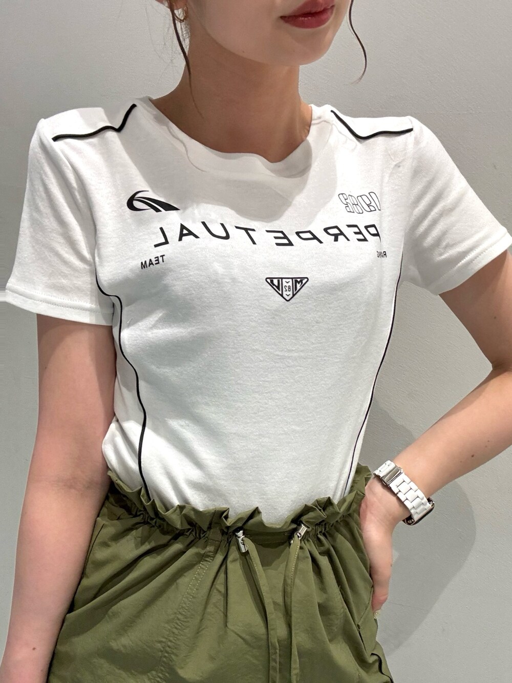 ホワイト系のTシャツ/カットソー、グリーン系のスカート、ブラック系のサンダルを着用したレディースの夏コーディネートの4枚目の写真