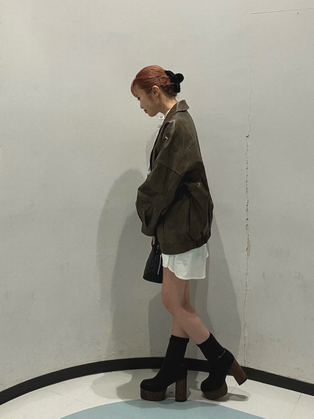 ブラウン系のブルゾン、グレー系のその他パンツ、ブラック系のハンドバッグを着用したレディースの冬コーディネートの4枚目の写真