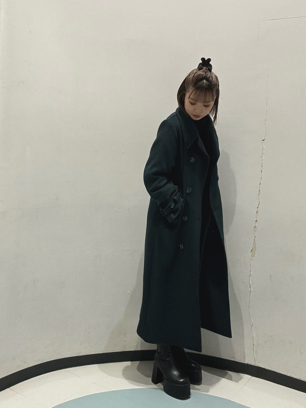 ホワイト系のハンドバッグ、ブラック系のワンピース、グリーン系のチェスターコートを着用したレディースの冬コーディネートの3枚目の写真