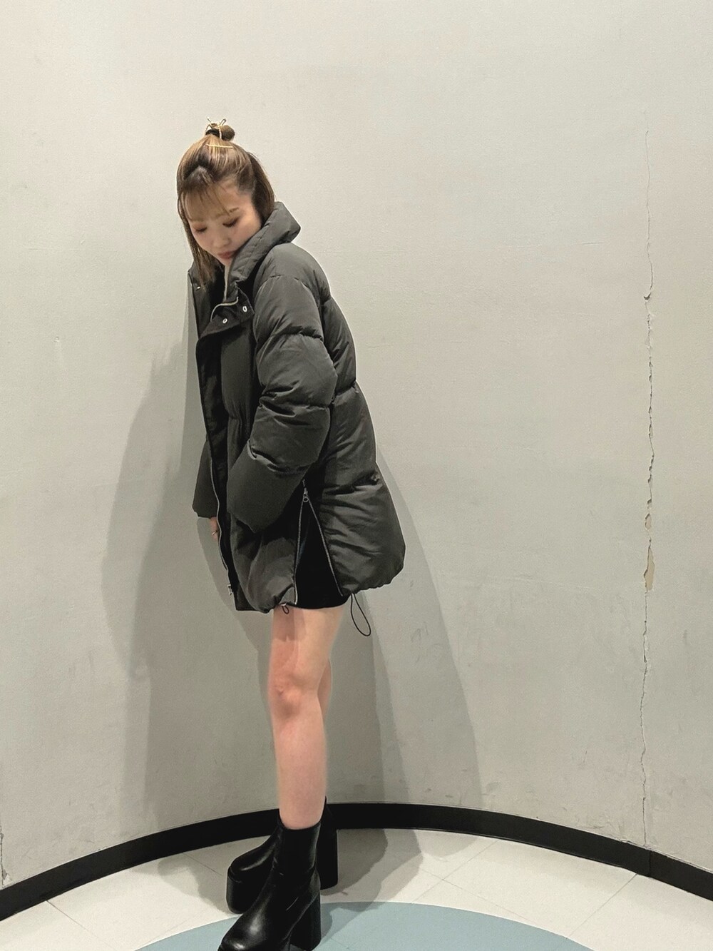 グレー系のダウンジャケット/コート、ホワイト系のニット/セーター、ブラック系のショルダーバッグを着用したレディースの秋コーディネートの3枚目の写真