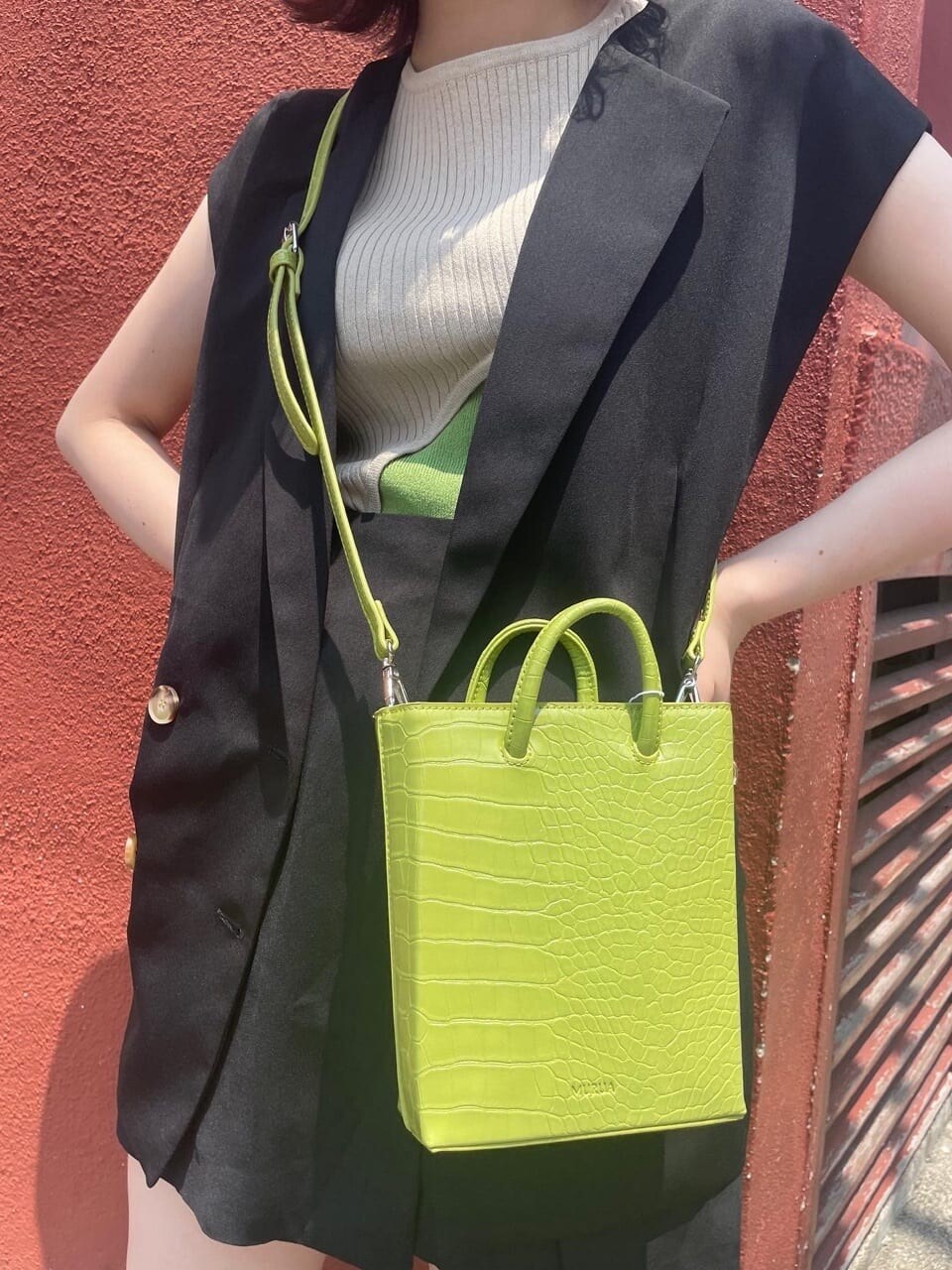 ブラック系のベスト、ブラック系のスラックス、ブラック系のサンダルを着用したレディースの夏コーディネートの4枚目の写真