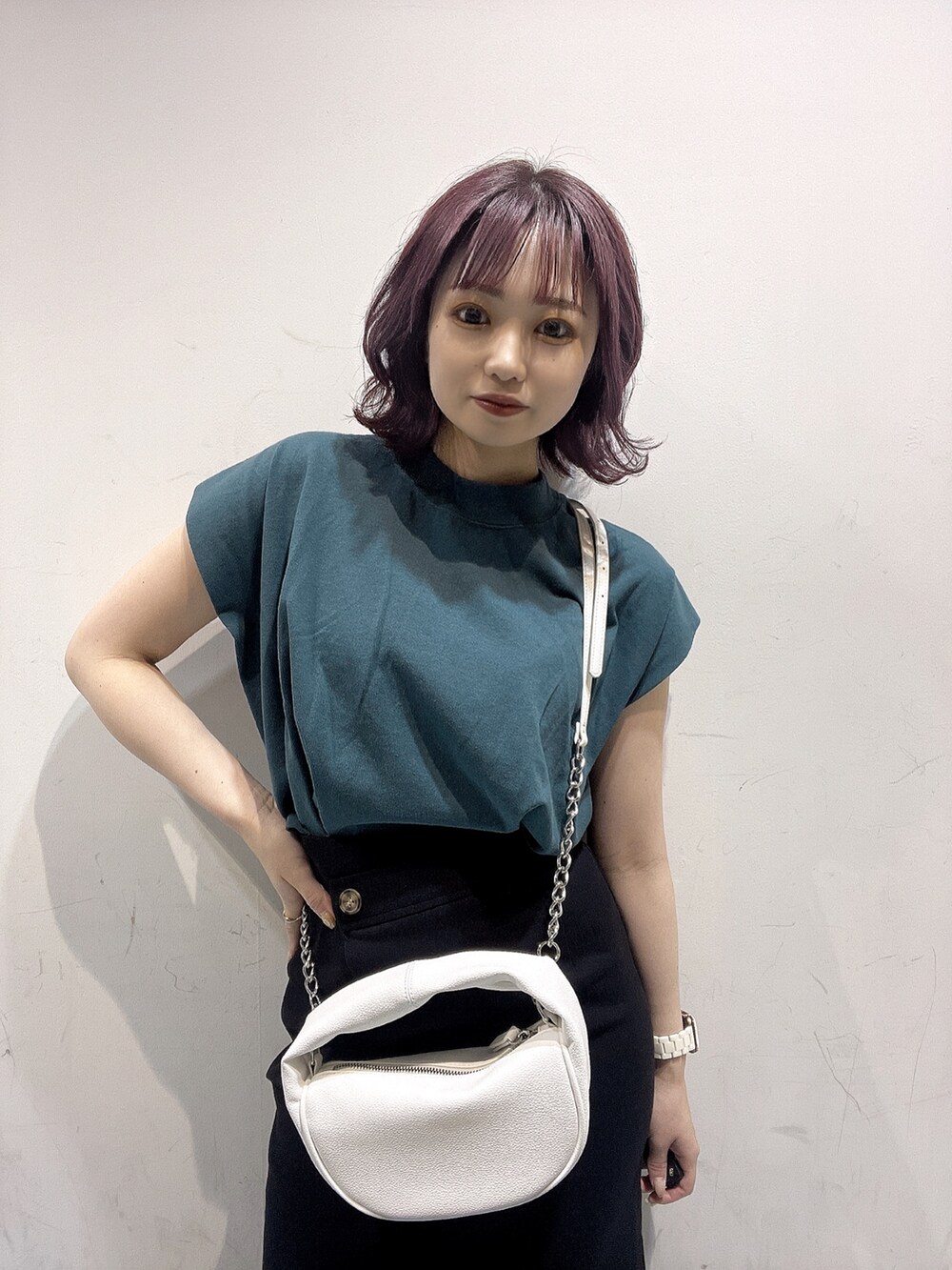 ホワイト系のハンドバッグ、ブラック系のサンダル、グリーン系のTシャツ/カットソーを着用したレディースの春コーディネートの3枚目の写真