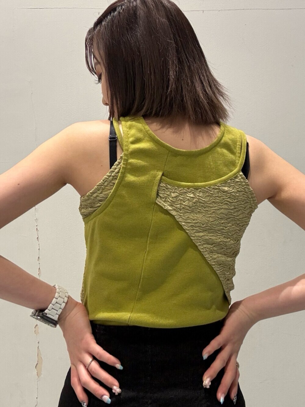 ブラック系のサンダル、グリーン系のタンクトップ、ブラック系のハンドバッグを着用したレディースの夏コーディネートの5枚目の写真