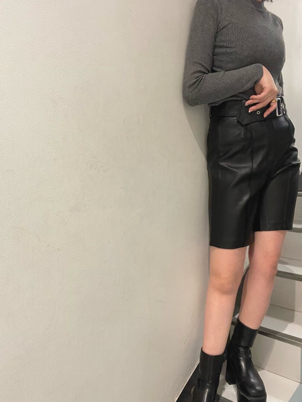グレー系のニット/セーター、ブラック系のトレンチコート、ブラック系のその他パンツを着用したレディースの秋コーディネートの4枚目の写真