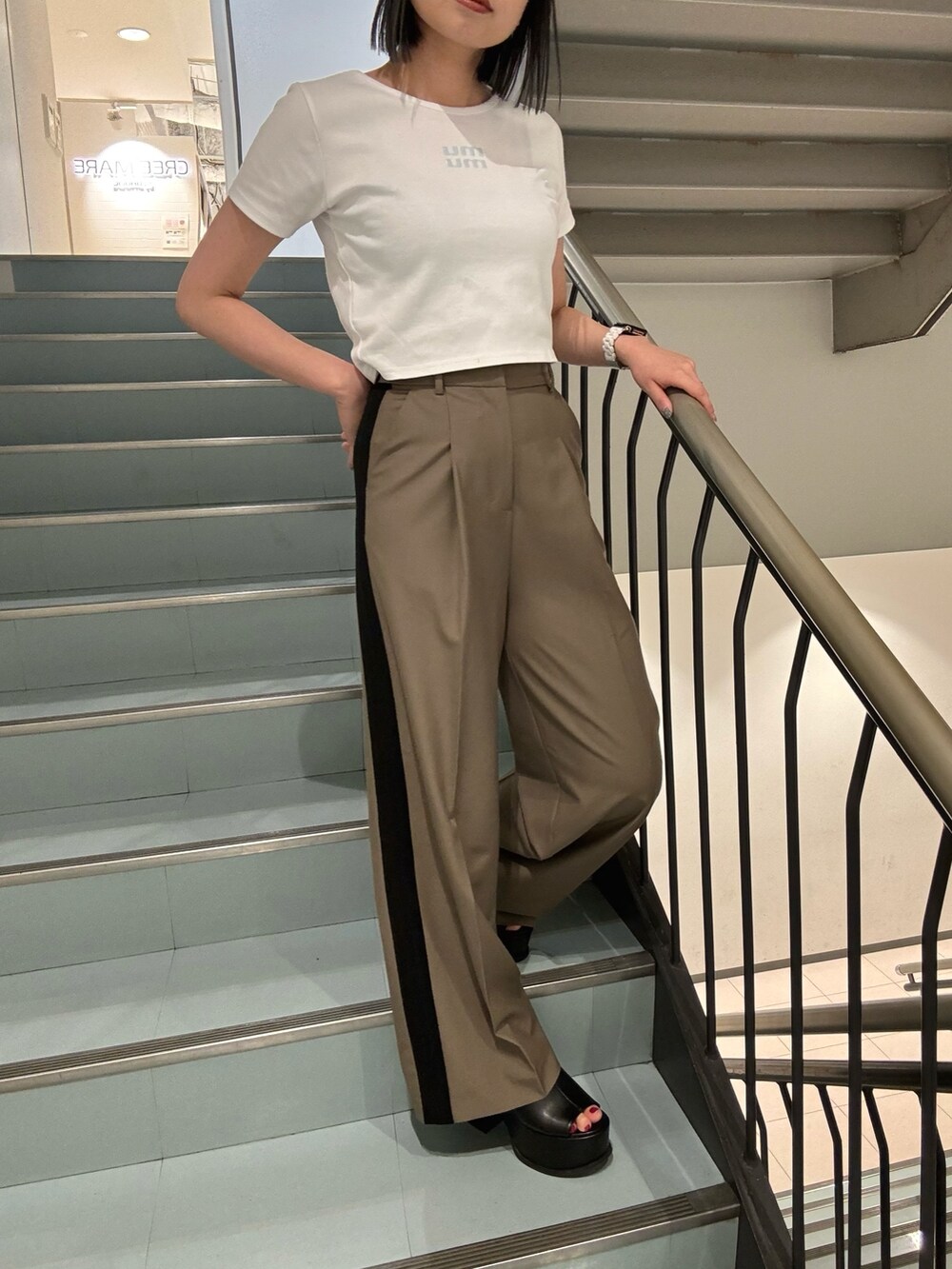 ブラック系のショルダーバッグ、ブラック系のサンダル、ホワイト系のTシャツ/カットソーを着用したレディースの春コーディネートの5枚目の写真