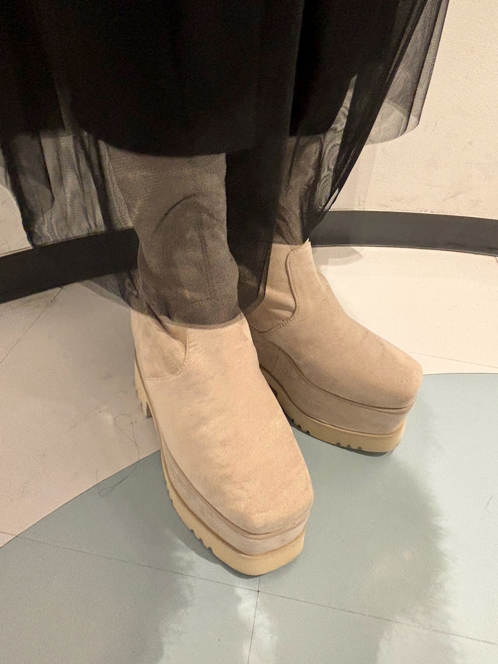 ホワイト系のニット/セーター、ブラック系のスカート、ホワイト系のブーツを着用したレディースの冬コーディネートの7枚目の写真