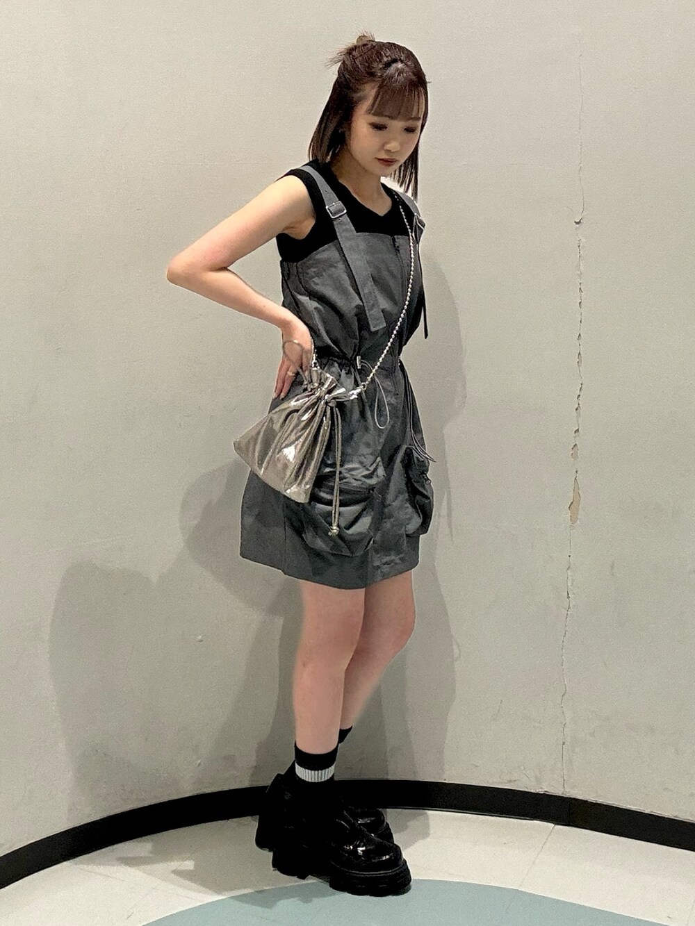 ブラック系のローファー、オレンジ系のニット/セーター、グレー系のワンピースを着用したレディースの春コーディネートの2枚目の写真