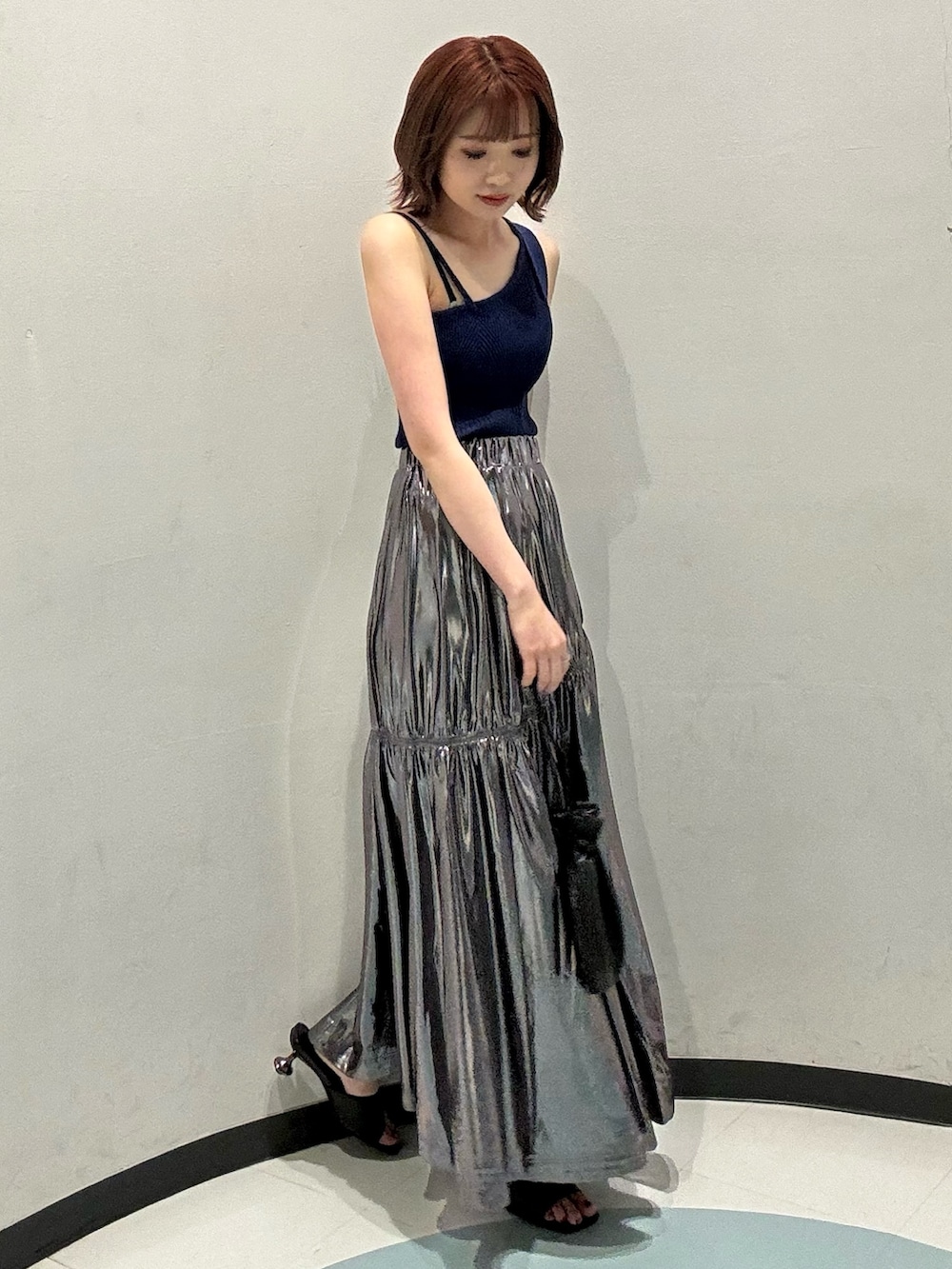 ブラック系のショルダーバッグ、ブラック系のサンダル、ブルー系のニット/セーターを着用したレディースの夏コーディネートの2枚目の写真