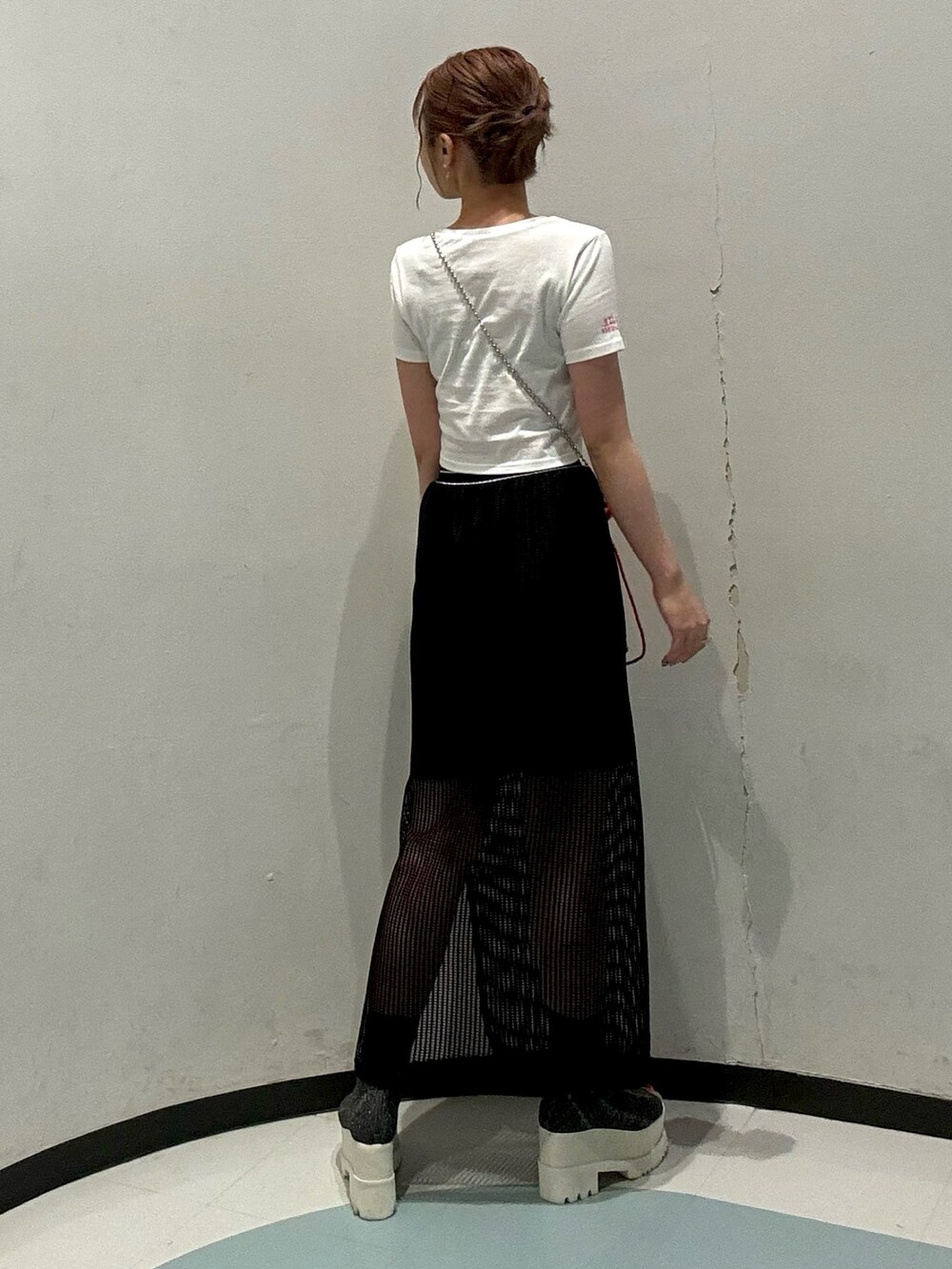 ホワイト系のTシャツ/カットソー、ブラック系のスカート、オレンジ系のショルダーバッグを着用したレディースの夏コーディネートの3枚目の写真