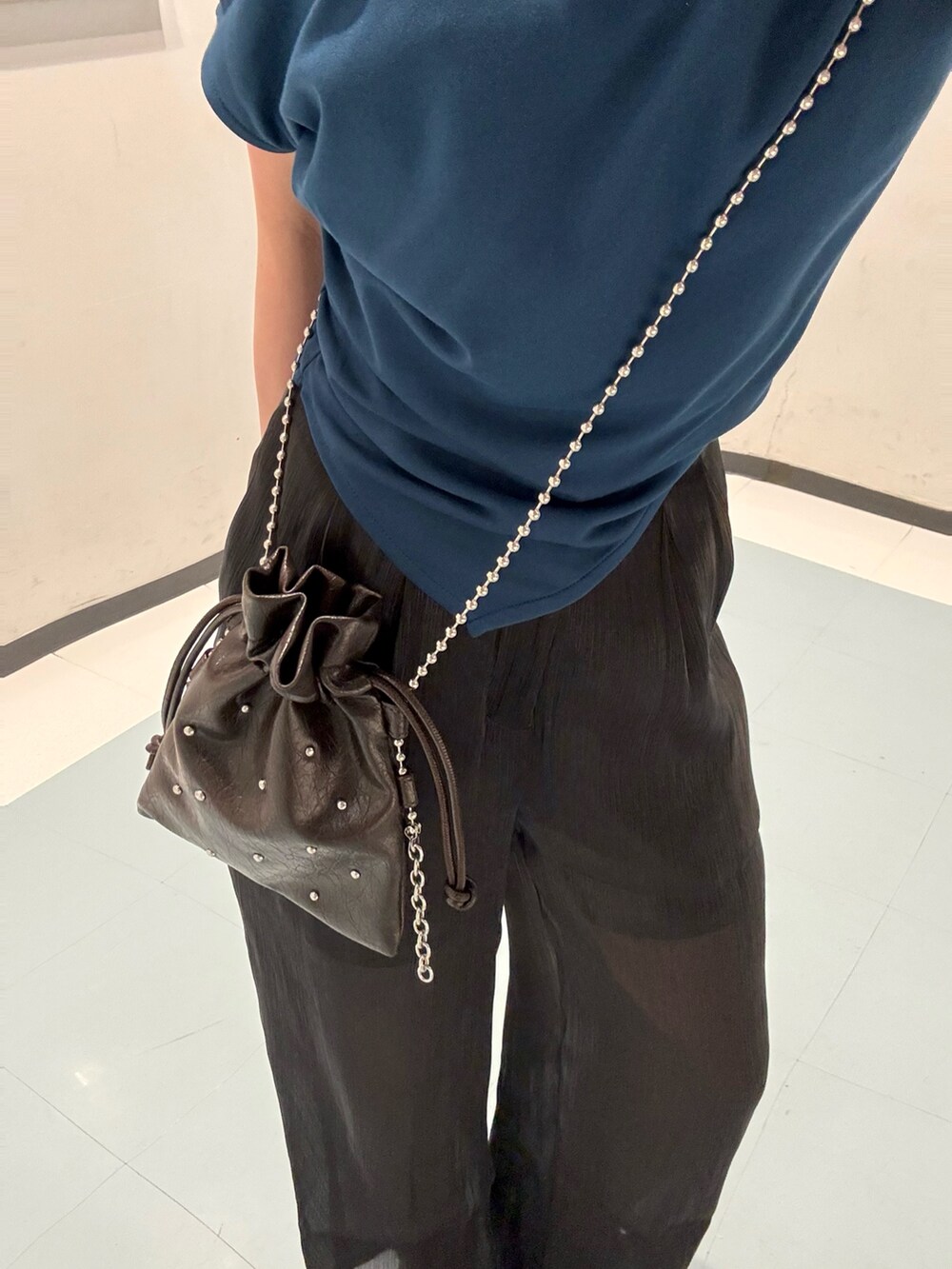 ブラック系のその他パンツ、ブラウン系のショルダーバッグ、ブルー系のTシャツ/カットソーを着用したレディースの夏コーディネートの4枚目の写真