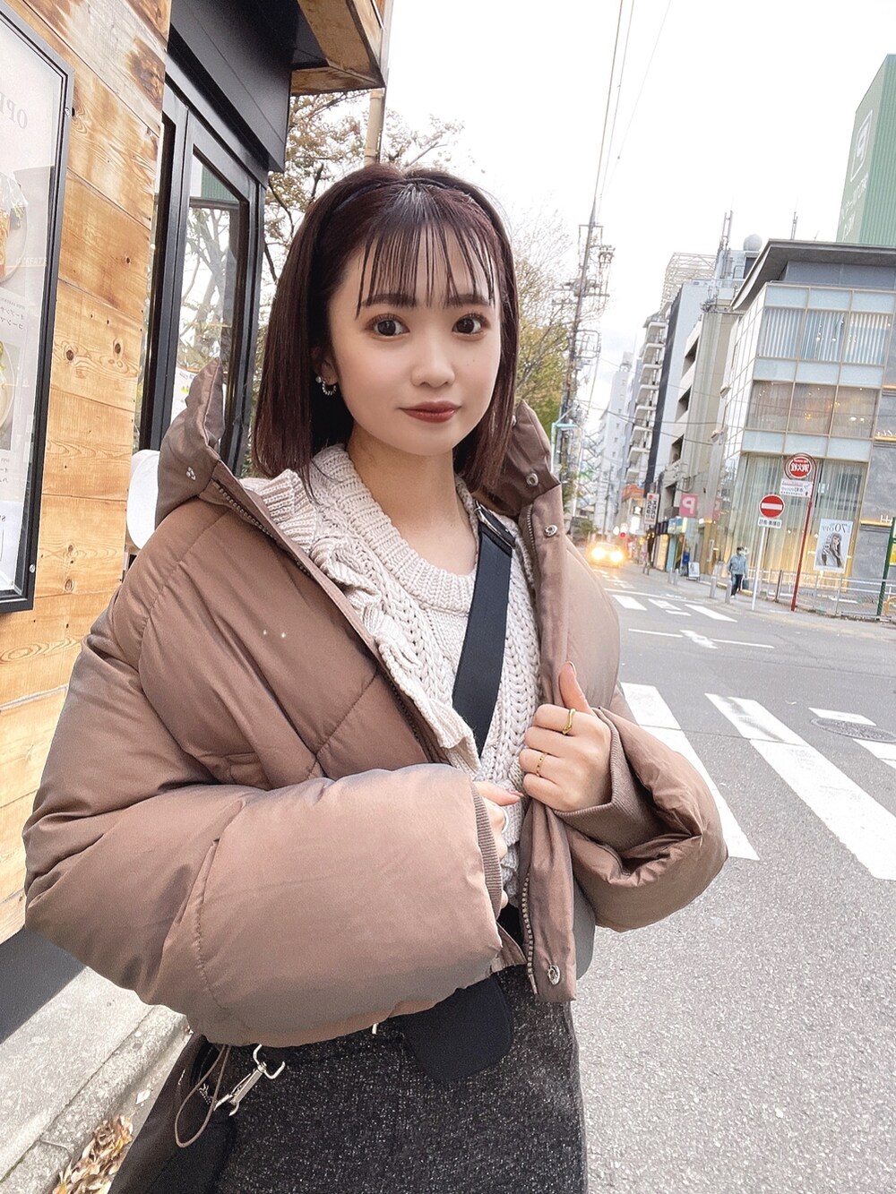 グレー系のニット/セーター、ブラック系のスカート、ブラウン系のダウンジャケット/コートを着用したレディースの冬コーディネートの5枚目の写真