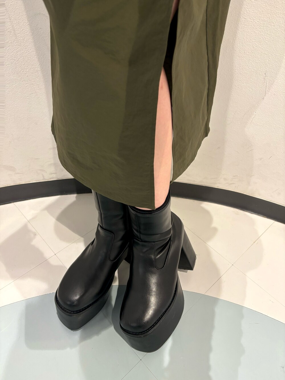 ブラック系のハンドバッグ、ブラック系のTシャツ/カットソー、ブラック系のブーツを着用したレディースの秋コーディネートの7枚目の写真