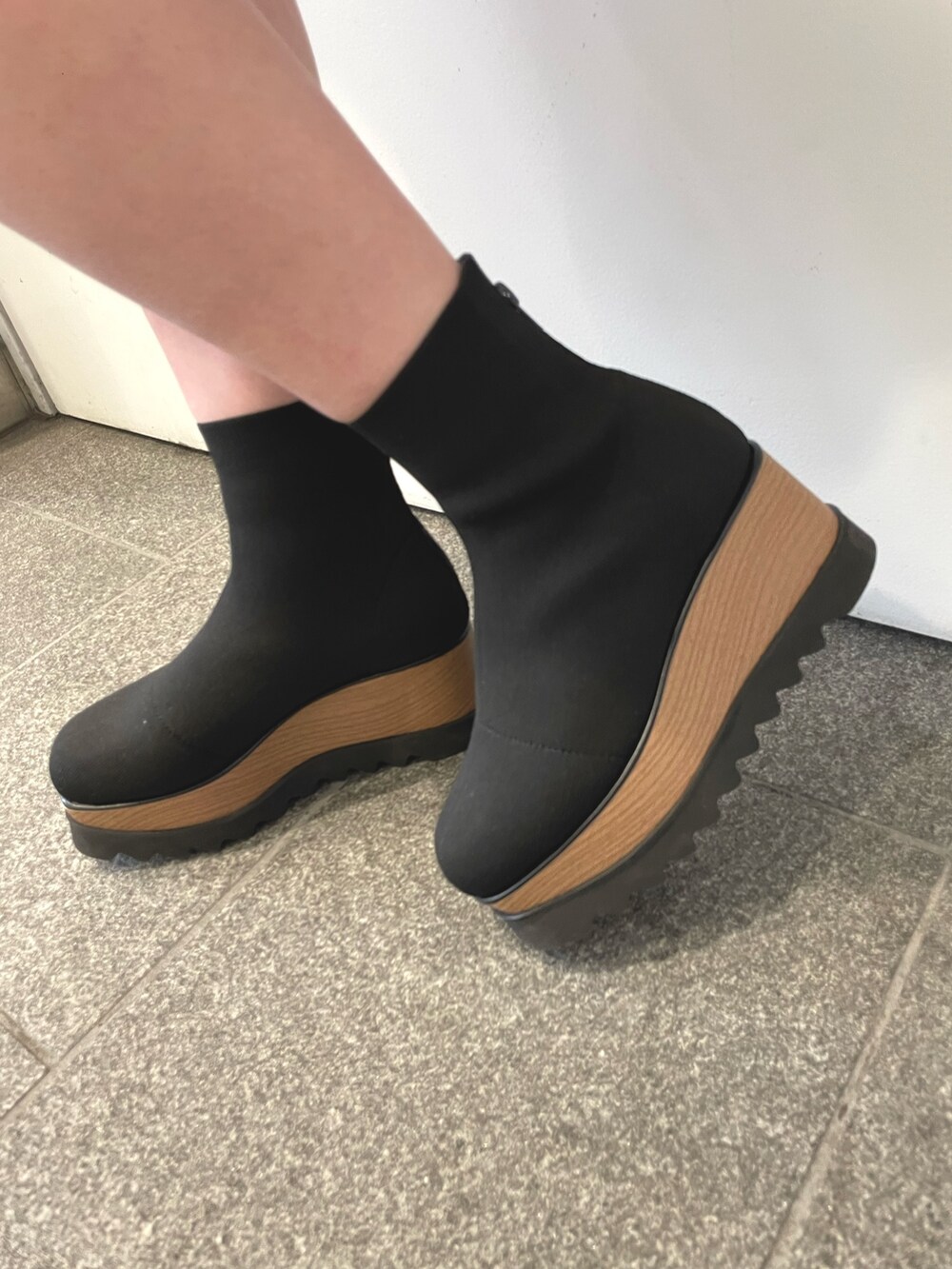 ベージュ系のカーディガン/ボレロ、ブラック系のブーツ、ブラック系のハンドバッグを着用したレディースの秋コーディネートの3枚目の写真