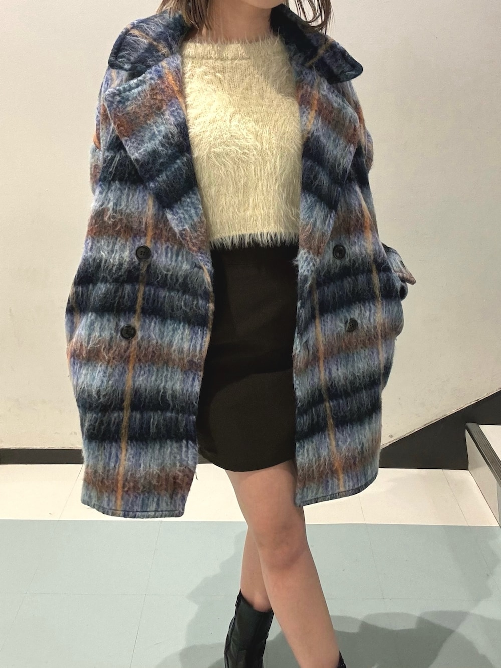 ブルー系のピーコート、ホワイト系のニット/セーター、ブラック系のスカートを着用したレディースの秋コーディネートの5枚目の写真