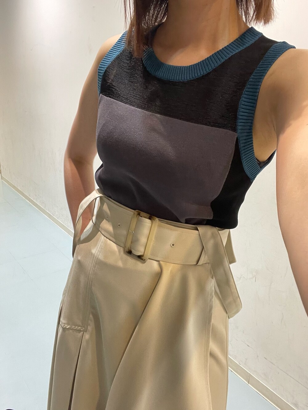 ホワイト系のジャンパースカート、ブルー系のニット/セーター、ブラック系のショルダーバッグを着用したレディースの夏コーディネートの6枚目の写真