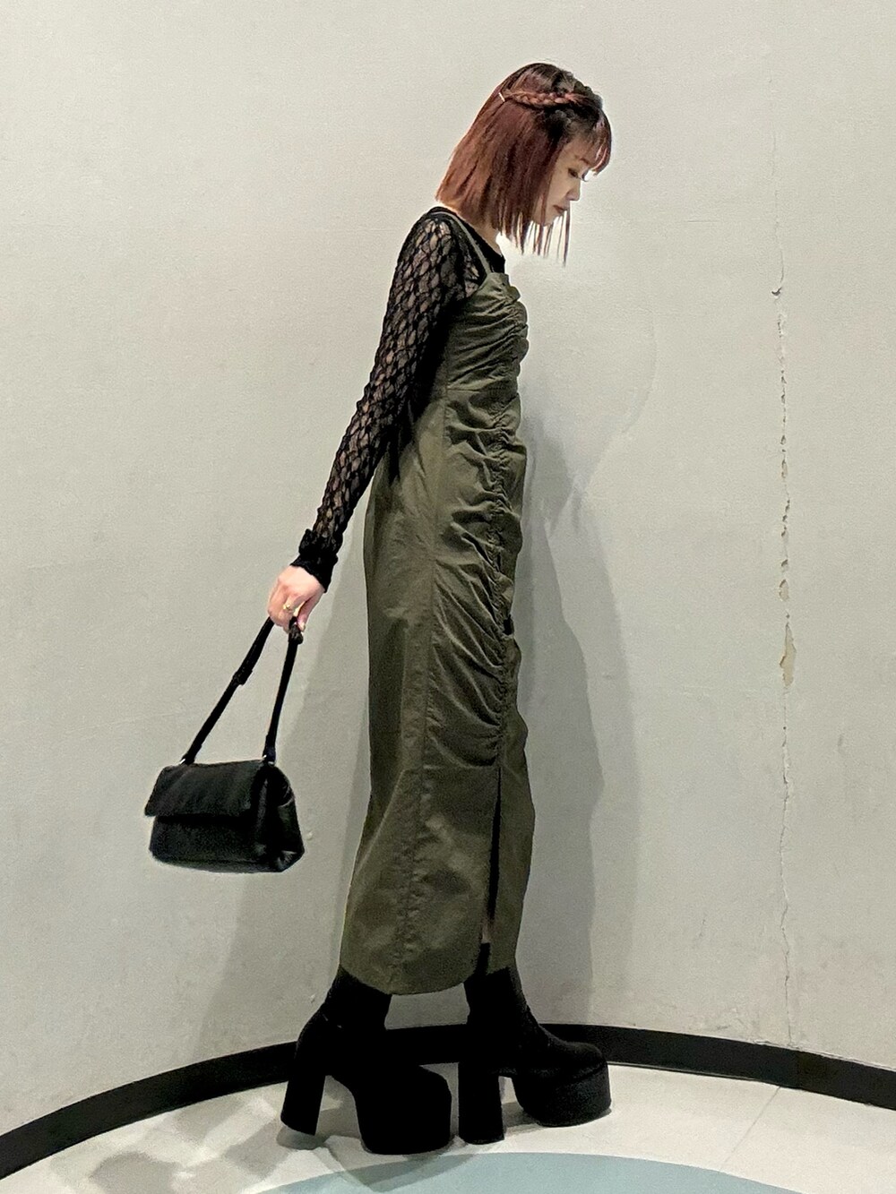 ブラック系のハンドバッグ、ブラック系のTシャツ/カットソー、ブラック系のブーツを着用したレディースの秋コーディネートの2枚目の写真