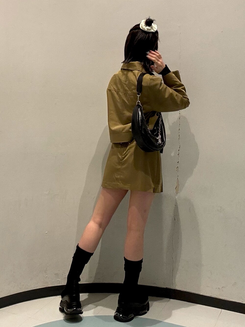 ブラック系のショルダーバッグ、ベージュ系のスカート、ベージュ系のブルゾンを着用したレディースの春コーディネートの3枚目の写真