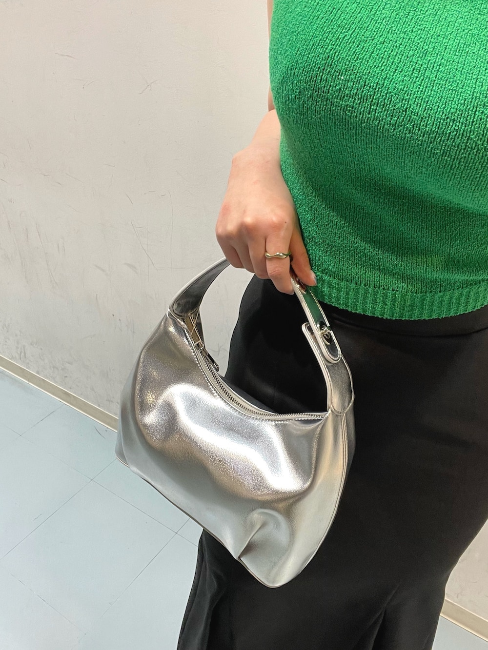 ブラック系のスカート、グリーン系のタンクトップ、ブラック系のサンダルを着用したレディースの春コーディネートの7枚目の写真