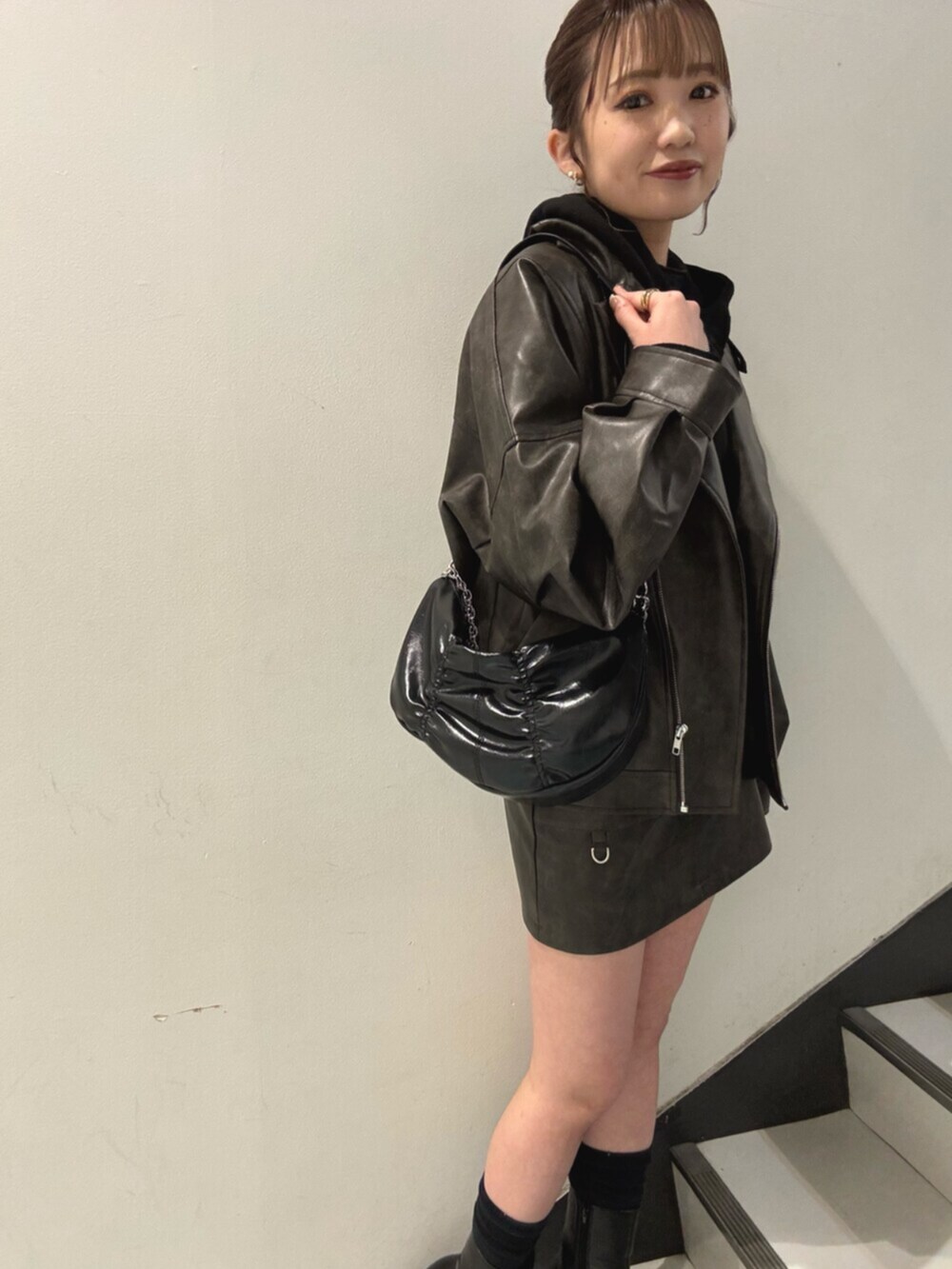 ブラック系のブーツ、ブラック系のパーカー、ブラウン系のブルゾンを着用したレディースの冬コーディネートの6枚目の写真