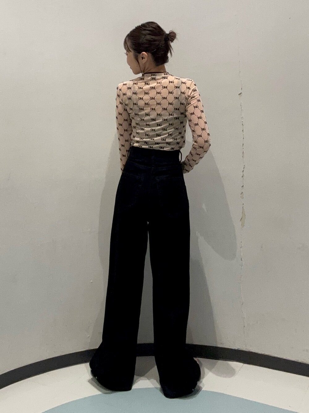 ブラック系のデニムパンツ、ベージュ系のTシャツ/カットソー、ブラック系のサンダルを着用したレディースの夏コーディネートの3枚目の写真