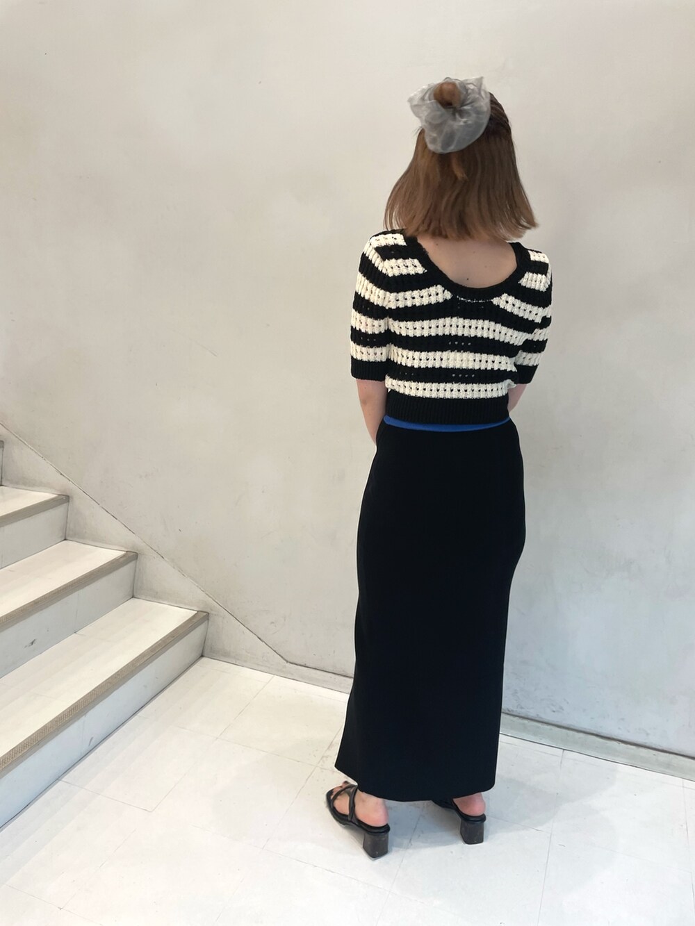 ブルー系のニット/セーター、ブラック系のサンダルを着用したレディースの春コーディネートの3枚目の写真