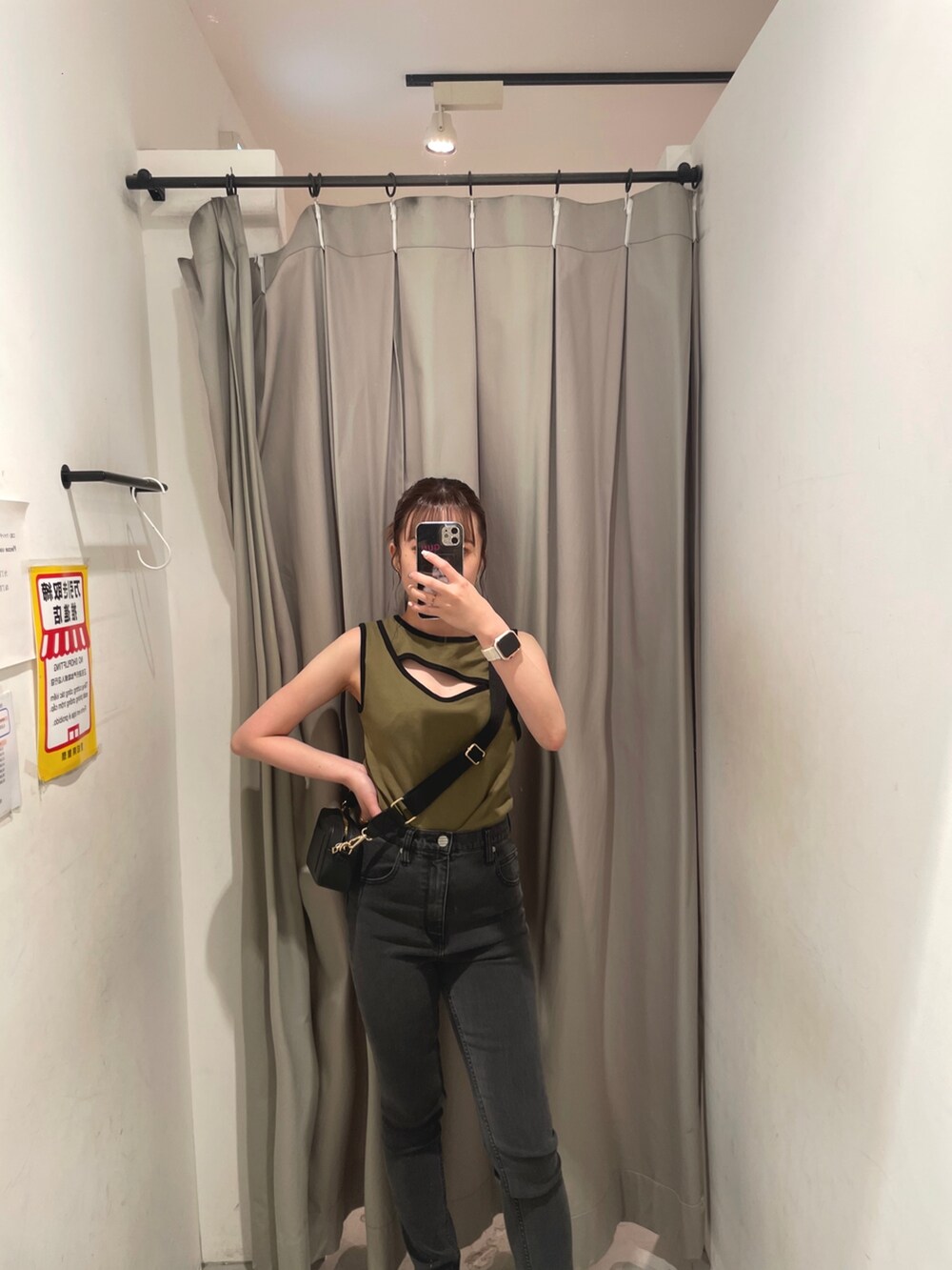 ブラック系のショルダーバッグ、グリーン系のタンクトップ、グレー系のデニムパンツを着用したレディースの夏コーディネートの2枚目の写真