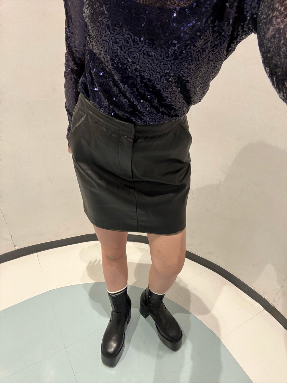 ブルー系のTシャツ/カットソー、ブラック系のライダースジャケット、ブラック系のスカートを着用したレディースの秋コーディネートの7枚目の写真