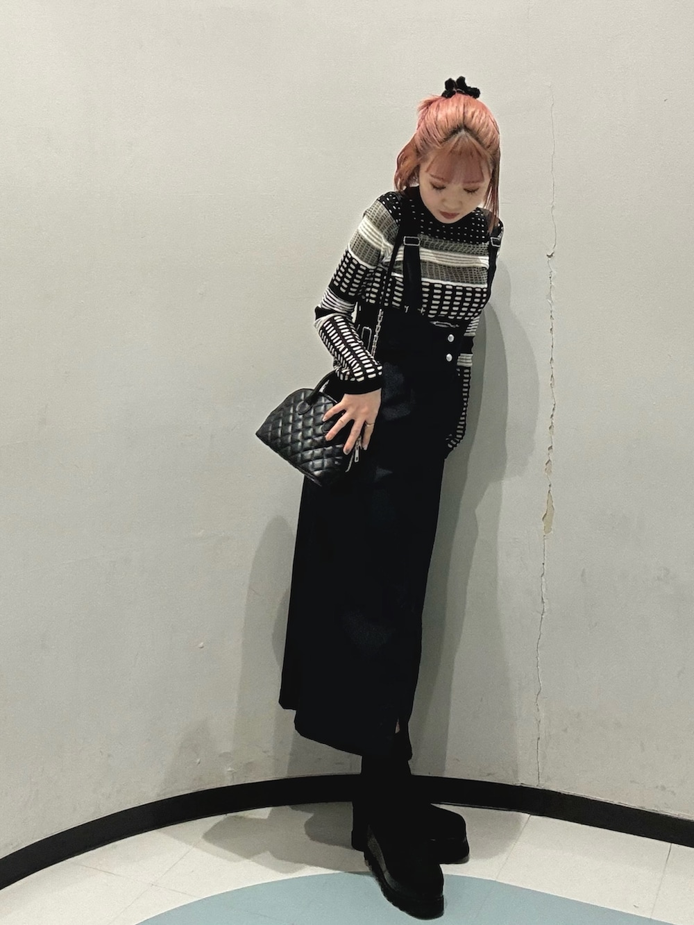 ブルー系のワンピース、ブラック系のハンドバッグ、ブラック系のブーツを着用したレディースの冬コーディネートの2枚目の写真