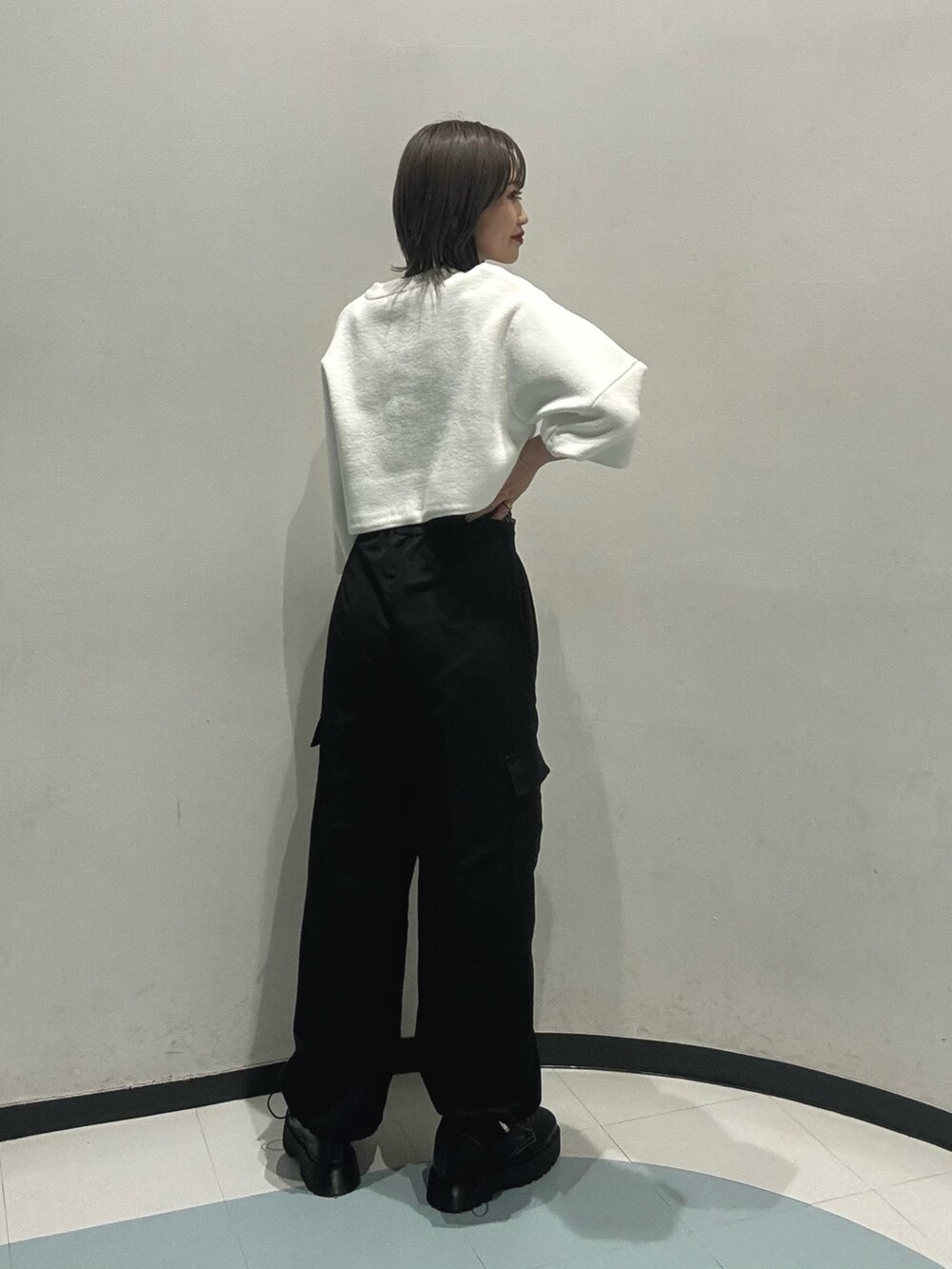 ブルー系のニット/セーター、ブラック系のその他パンツ、ブラック系のブーツを着用したレディースの冬コーディネートの2枚目の写真