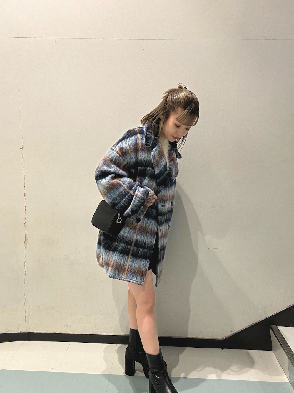 ブルー系のピーコート、ホワイト系のニット/セーター、ブラック系のスカートを着用したレディースの秋コーディネートの3枚目の写真