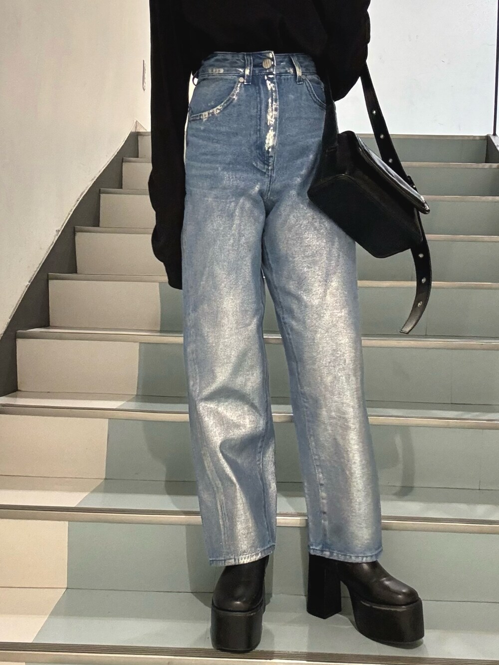 ブルー系のデニムパンツ、ブラック系のショルダーバッグ、グレー系のブルゾンを着用したレディースの冬コーディネートの6枚目の写真