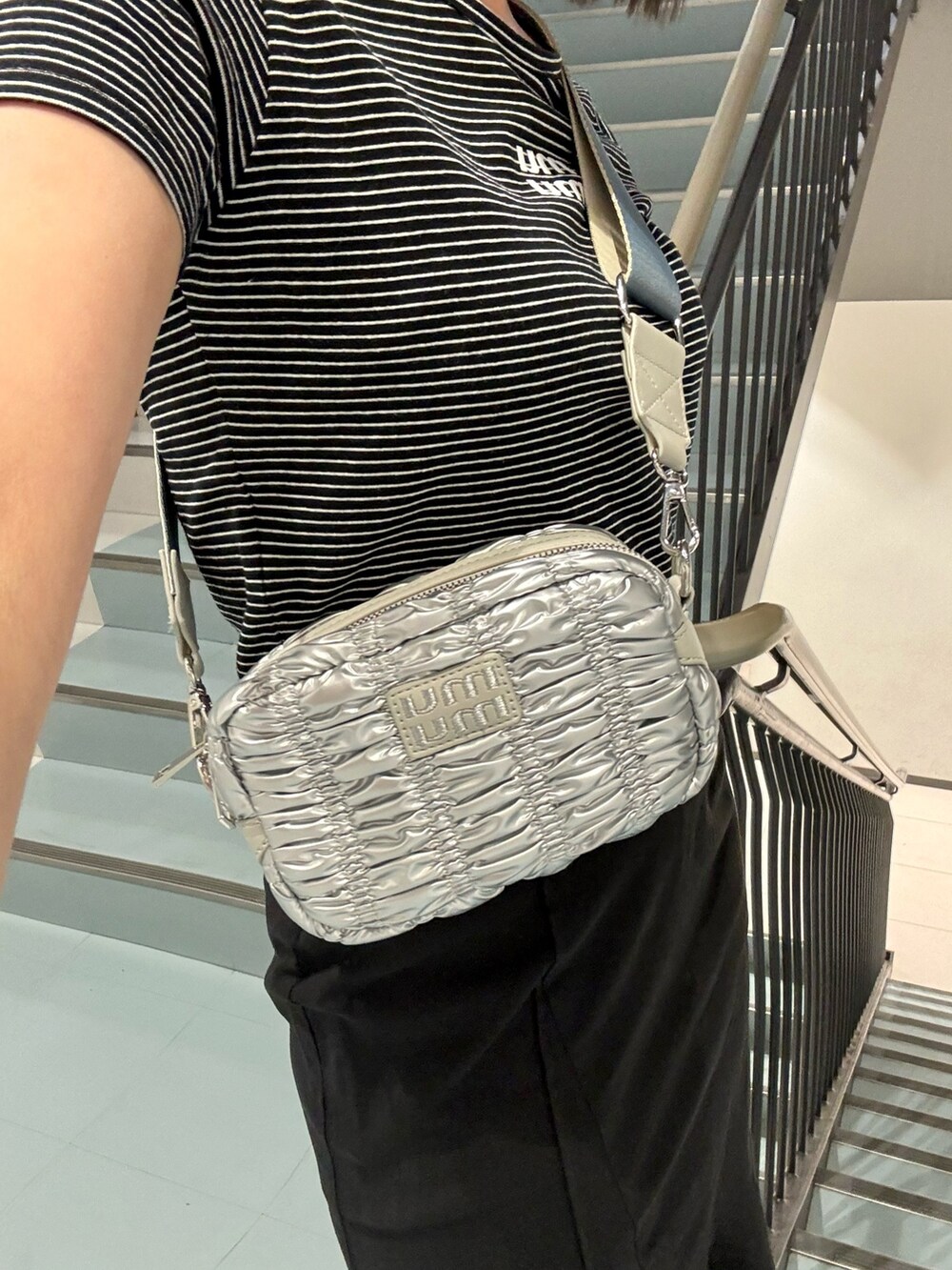 シルバー系のショルダーバッグ、ブラック系のスカート、その他のTシャツ/カットソーを着用したレディースの春コーディネートの7枚目の写真