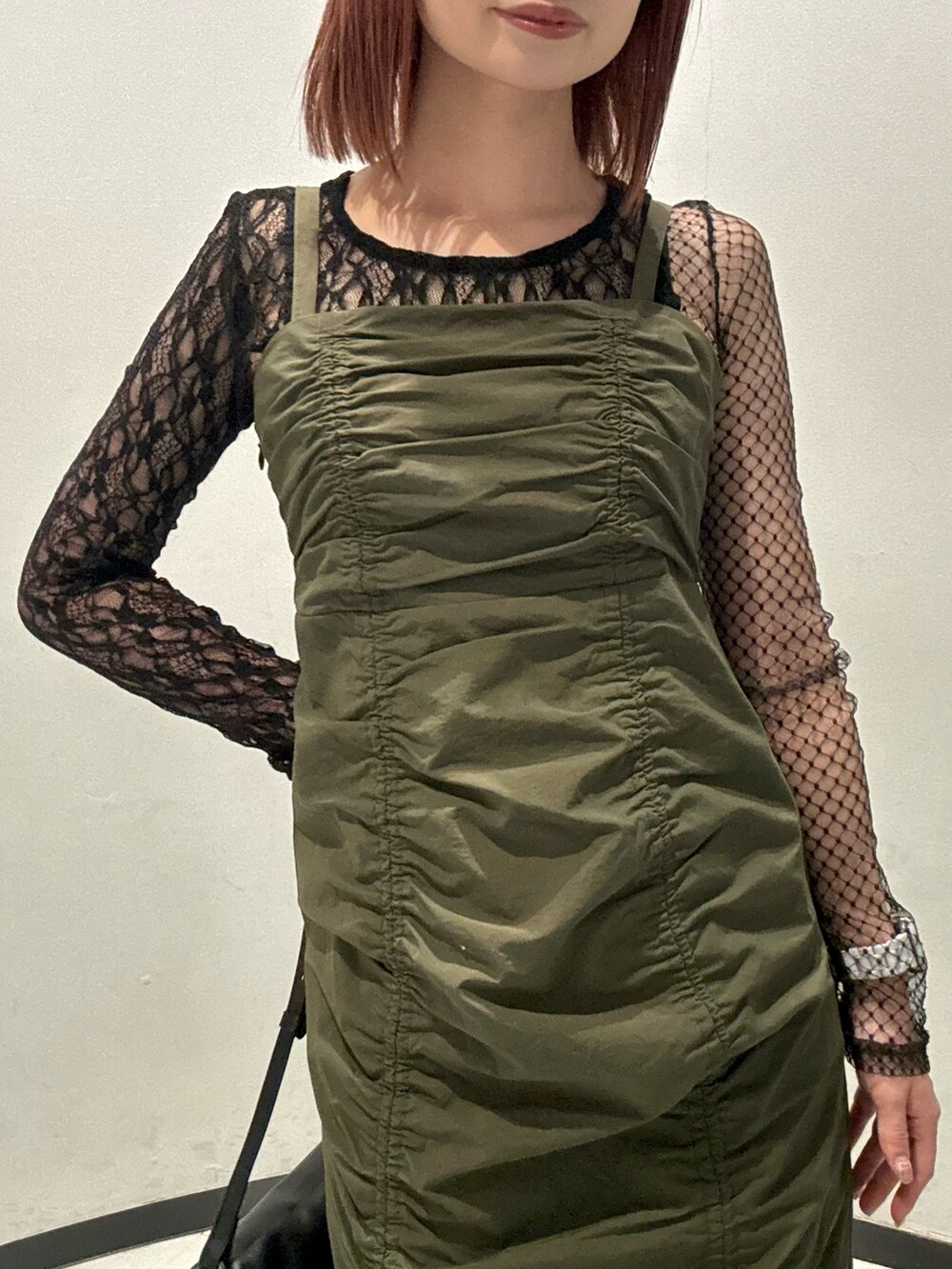 ブラック系のハンドバッグ、ブラック系のTシャツ/カットソー、ブラック系のブーツを着用したレディースの秋コーディネートの6枚目の写真