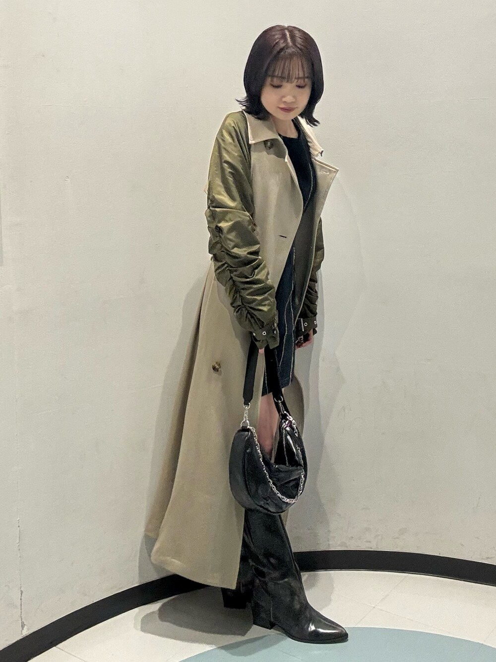 ブラック系のショルダーバッグ、ブラック系のブーツ、ブルー系のワンピースを着用したレディースの冬コーディネートの2枚目の写真