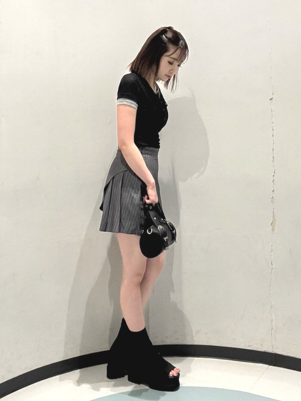 ブラック系のハンドバッグ、ブラック系のサンダル、ブラック系のTシャツ/カットソーを着用したレディースの夏コーディネートの2枚目の写真