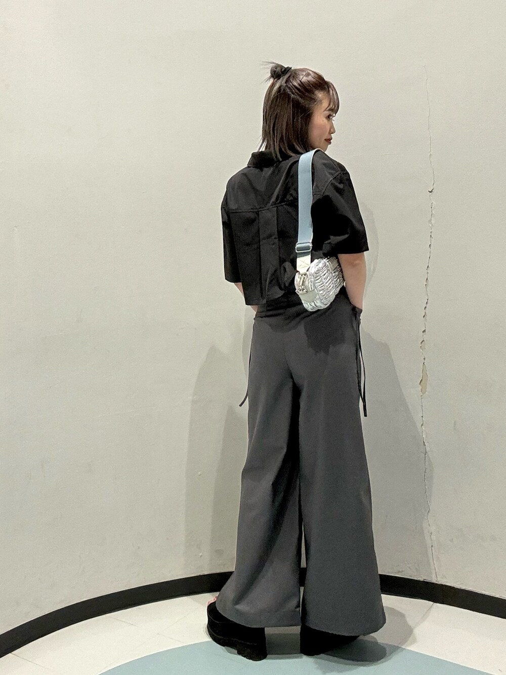 シルバー系のショルダーバッグ、ブラック系のシャツ/ブラウス、グレー系のその他パンツを着用したレディースの春コーディネートの3枚目の写真