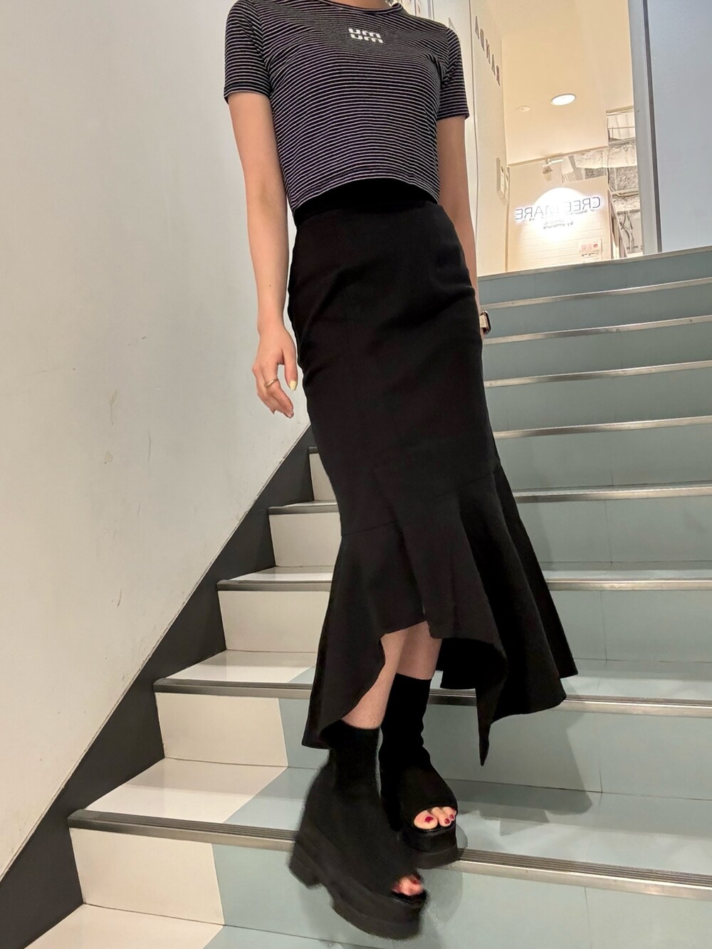 シルバー系のショルダーバッグ、ブラック系のスカート、その他のTシャツ/カットソーを着用したレディースの春コーディネートの5枚目の写真