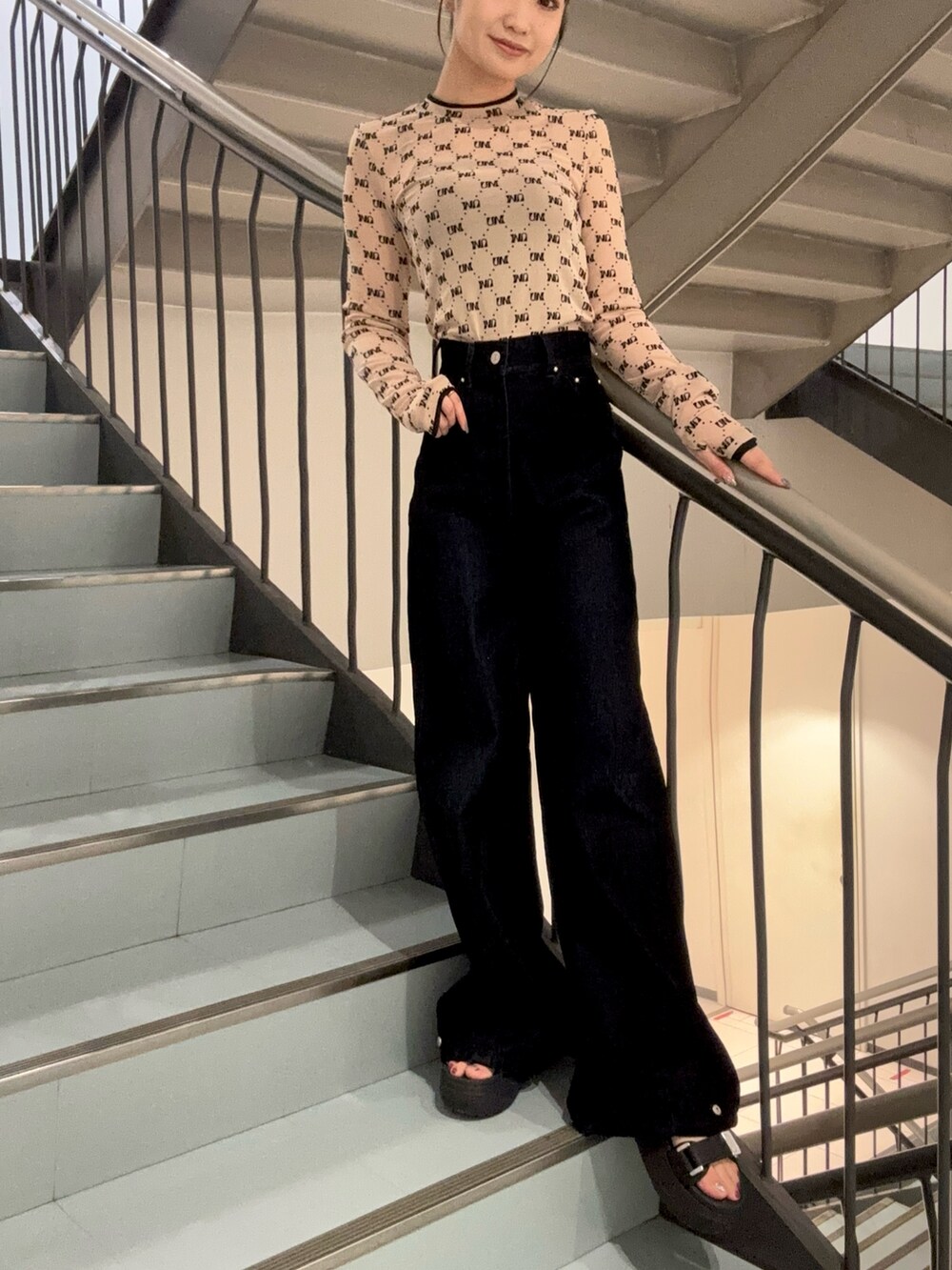 ブラック系のデニムパンツ、ベージュ系のTシャツ/カットソー、ブラック系のサンダルを着用したレディースの夏コーディネートの5枚目の写真