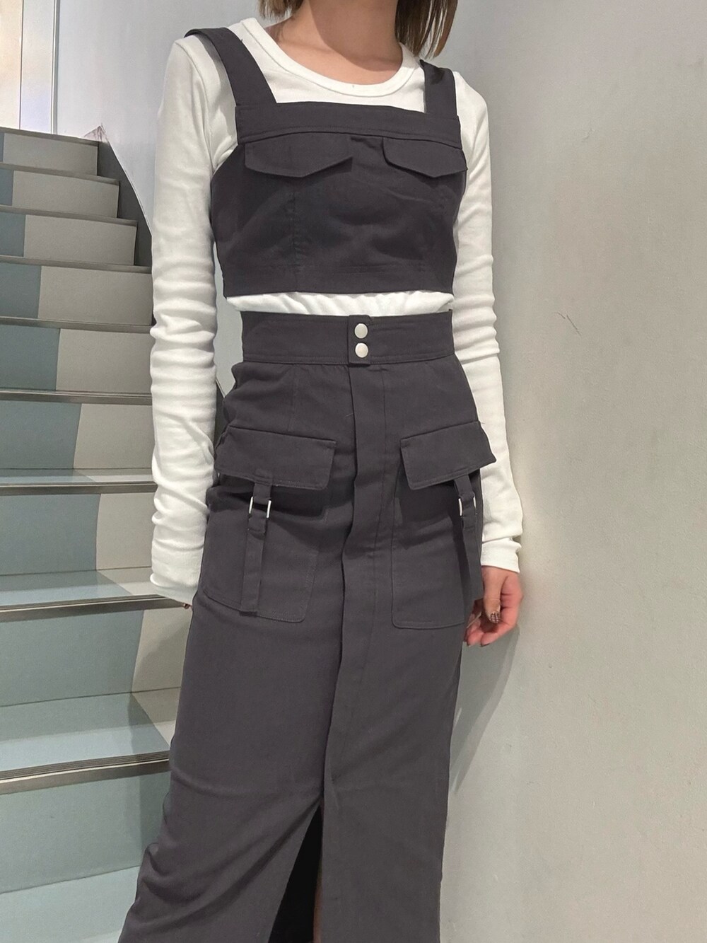 ホワイト系のTシャツ/カットソー、グレー系のワンピース、ブラック系のサンダルを着用したレディースの冬コーディネートの4枚目の写真