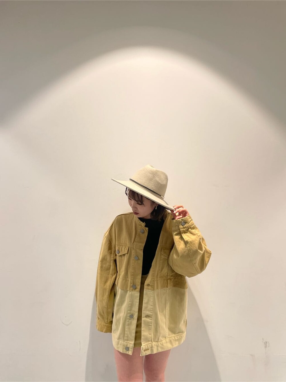 ホワイト系のハンドバッグ、イエロー系のデニムジャケット、イエロー系のスカートを着用したレディースの冬コーディネートの4枚目の写真