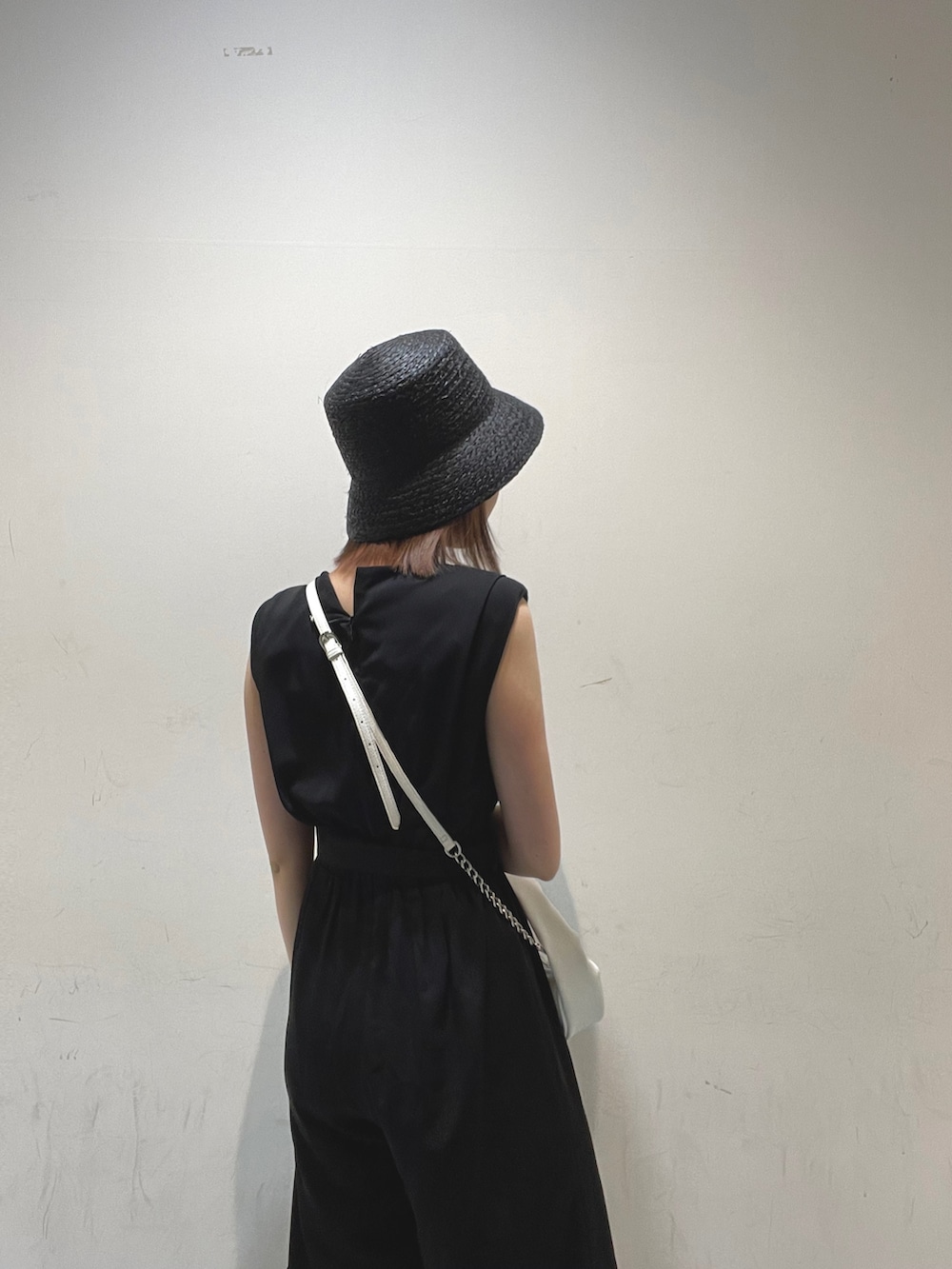 ホワイト系のハンドバッグ、ブラック系のサロペット/オーバーオールを着用したレディースの夏コーディネートの5枚目の写真